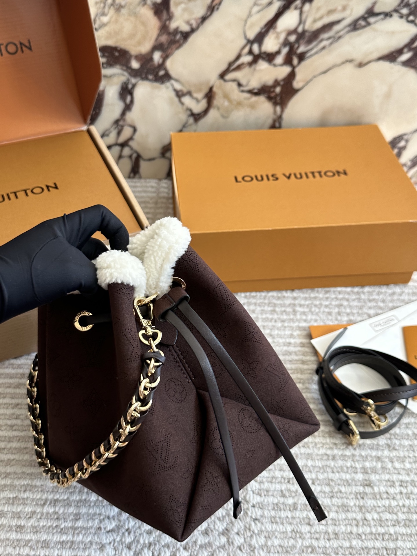 💰180 LV高版本 bella 小水桶 手袋系列 采用Monogram镂花穿孔小牛皮塑造小巧构型,再令相同图案以袖珍比例栖身圆形零钱包,洋溢摩登风尚。金属与皮革编织手柄和可拆卸皮革肩带实现多种背携方式。尺寸22 18cm