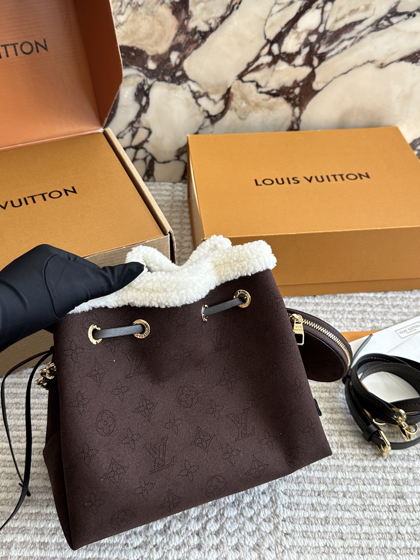 💰180 LV高版本 bella 小水桶 手袋系列 采用Monogram镂花穿孔小牛皮塑造小巧构型,再令相同图案以袖珍比例栖身圆形零钱包,洋溢摩登风尚。金属与皮革编织手柄和可拆卸皮革肩带实现多种背携方式。尺寸22 18cm