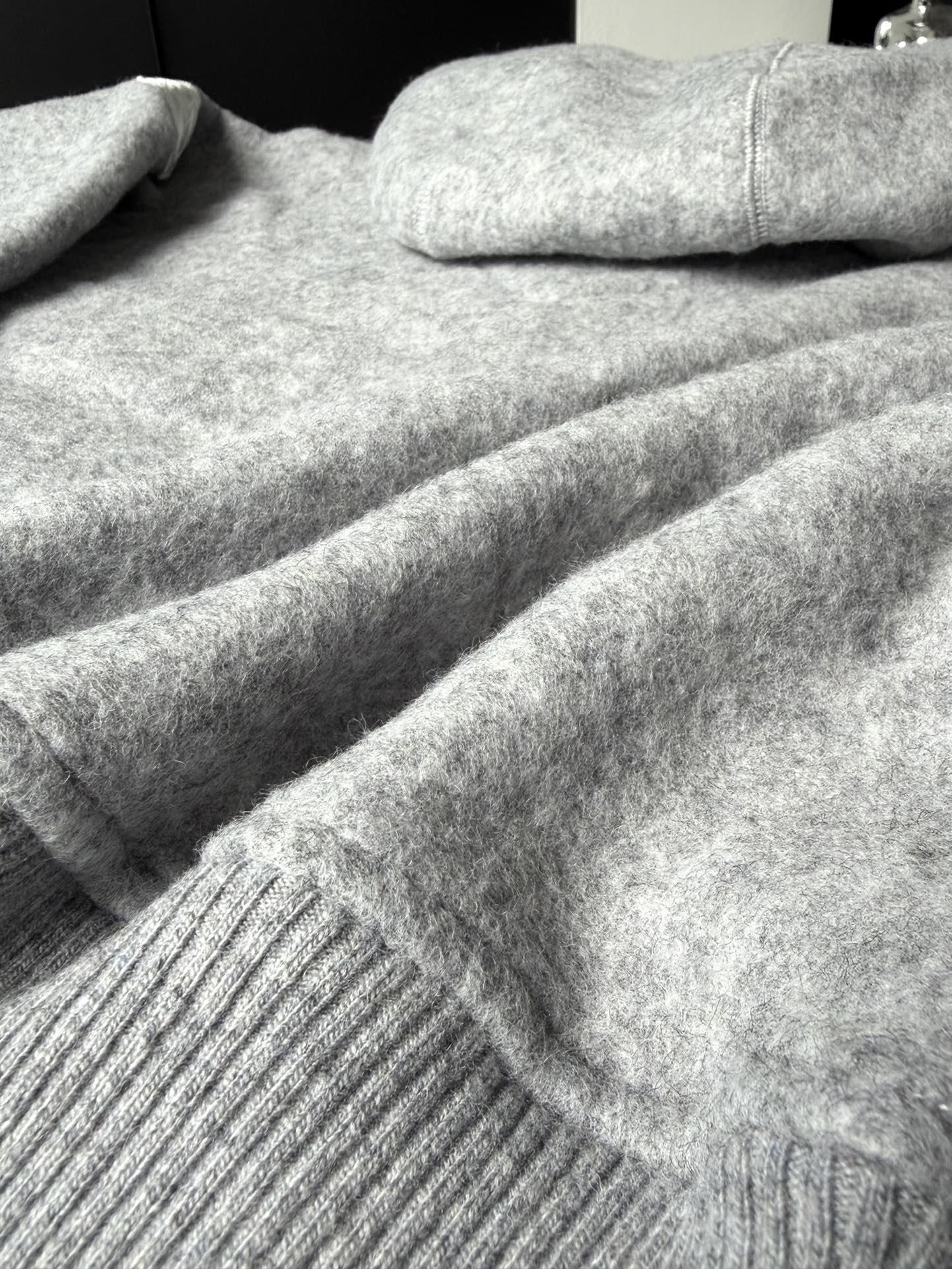 大鹅/Canada Goose抓绒羊毛饰章连帽夹克外套 面料选择: 以羊毛为主体，加入极少量氨纶和聚酯纤维混纺而成的羊毛抓绒面料。羊毛作为核心天然成分，提供无与伦比的温度调节、抑菌防臭和亲肤感。少量氨纶的喂入赋予了面料一定的四向弹性，日常活动时毫无束缚感。作为抓绒结构的基础，聚酯纤维增强了面料的耐久性、抗皱性和快干性，它构成了抓绒的蓬松感，并提供锁住空气等功能。 细节1: 衣袖和下摆采用2乘2罗纹收口，其强大的弹性，可以紧密贴合不同粗细的手腕和腰部，形成一个有效的&lsquo;密封&rsquo;,防止冷风倒灌。在多次拉伸和使用后仍能保持原有形状，不易松垮变形。且罗纹袖口能传递一种设计感，强化视觉美观度。 细节2: 兜帽设计与松紧扣的搭配提升穿戴时的保暖度与防风性能。 辅料:定制弹性抽绳松紧扣定制拉链吊坠定制臂章 尺码：S M L 颜色：黑 灰 咖 米 粉