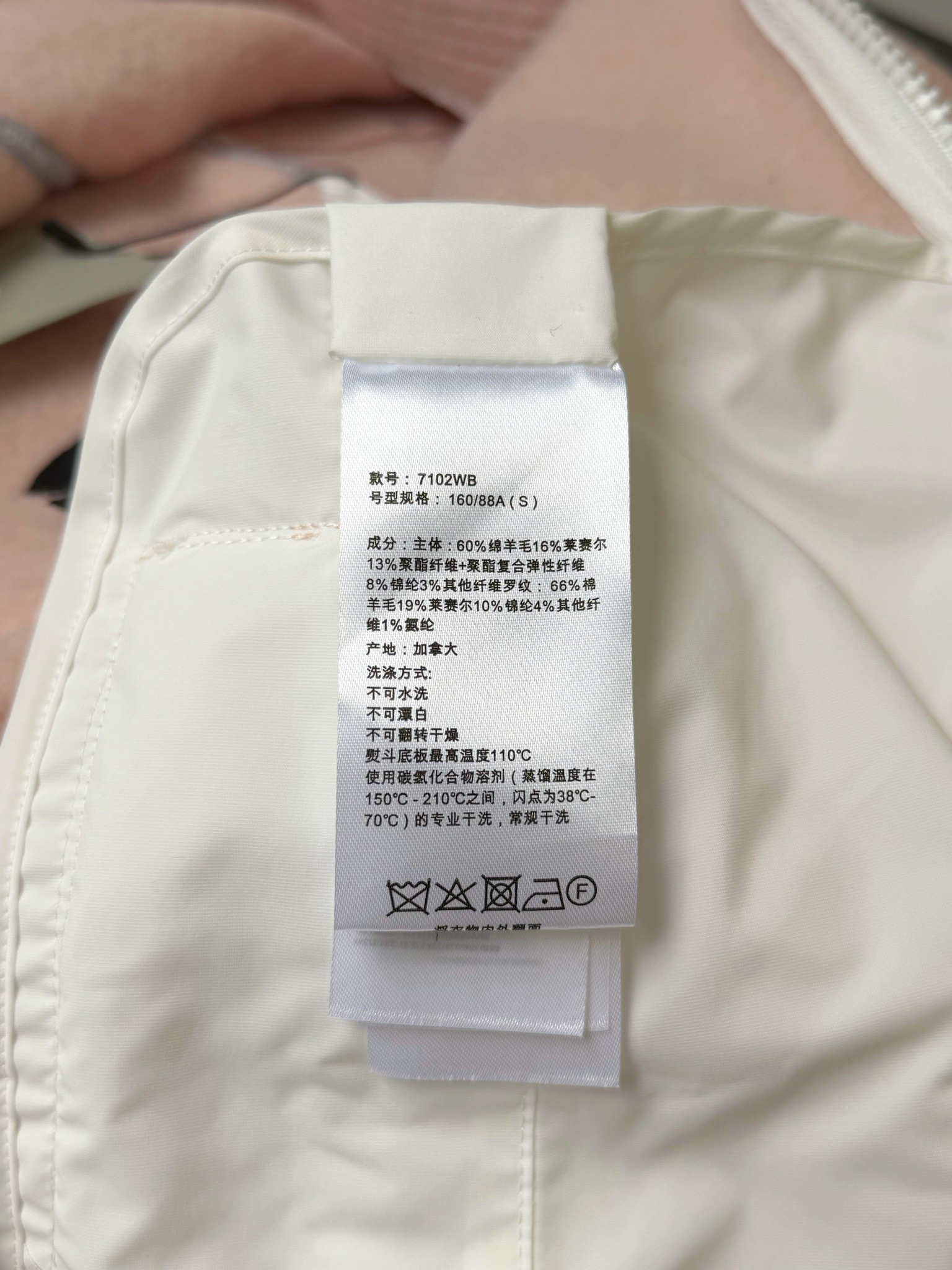 大鹅/Canada Goose抓绒羊毛饰章连帽夹克外套 面料选择: 以羊毛为主体，加入极少量氨纶和聚酯纤维混纺而成的羊毛抓绒面料。羊毛作为核心天然成分，提供无与伦比的温度调节、抑菌防臭和亲肤感。少量氨纶的喂入赋予了面料一定的四向弹性，日常活动时毫无束缚感。作为抓绒结构的基础，聚酯纤维增强了面料的耐久性、抗皱性和快干性，它构成了抓绒的蓬松感，并提供锁住空气等功能。 细节1: 衣袖和下摆采用2乘2罗纹收口，其强大的弹性，可以紧密贴合不同粗细的手腕和腰部，形成一个有效的&lsquo;密封&rsquo;,防止冷风倒灌。在多次拉伸和使用后仍能保持原有形状，不易松垮变形。且罗纹袖口能传递一种设计感，强化视觉美观度。 细节2: 兜帽设计与松紧扣的搭配提升穿戴时的保暖度与防风性能。 辅料:定制弹性抽绳松紧扣定制拉链吊坠定制臂章 尺码：S M L 颜色：黑 灰 咖 米 粉