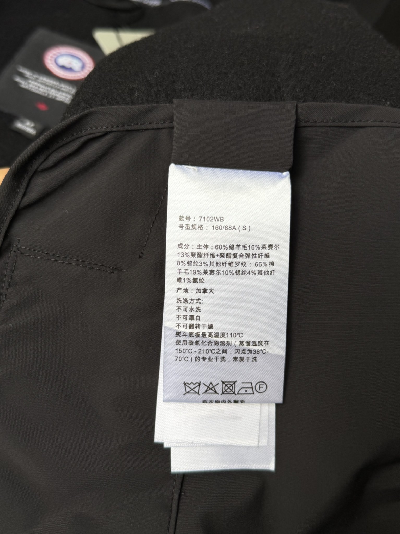 大鹅/Canada Goose抓绒羊毛饰章连帽夹克外套 面料选择: 以羊毛为主体，加入极少量氨纶和聚酯纤维混纺而成的羊毛抓绒面料。羊毛作为核心天然成分，提供无与伦比的温度调节、抑菌防臭和亲肤感。少量氨纶的喂入赋予了面料一定的四向弹性，日常活动时毫无束缚感。作为抓绒结构的基础，聚酯纤维增强了面料的耐久性、抗皱性和快干性，它构成了抓绒的蓬松感，并提供锁住空气等功能。 细节1: 衣袖和下摆采用2乘2罗纹收口，其强大的弹性，可以紧密贴合不同粗细的手腕和腰部，形成一个有效的&lsquo;密封&rsquo;,防止冷风倒灌。在多次拉伸和使用后仍能保持原有形状，不易松垮变形。且罗纹袖口能传递一种设计感，强化视觉美观度。 细节2: 兜帽设计与松紧扣的搭配提升穿戴时的保暖度与防风性能。 辅料:定制弹性抽绳松紧扣定制拉链吊坠定制臂章 尺码：S M L 颜色：黑 灰 咖 米 粉
