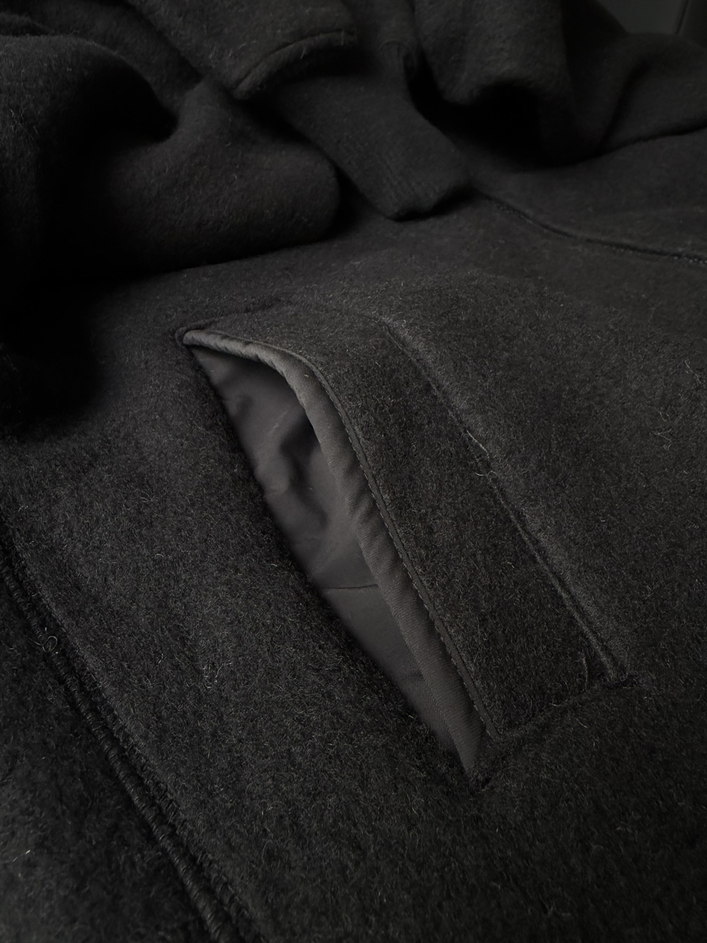 大鹅/Canada Goose抓绒羊毛饰章连帽夹克外套 面料选择: 以羊毛为主体，加入极少量氨纶和聚酯纤维混纺而成的羊毛抓绒面料。羊毛作为核心天然成分，提供无与伦比的温度调节、抑菌防臭和亲肤感。少量氨纶的喂入赋予了面料一定的四向弹性，日常活动时毫无束缚感。作为抓绒结构的基础，聚酯纤维增强了面料的耐久性、抗皱性和快干性，它构成了抓绒的蓬松感，并提供锁住空气等功能。 细节1: 衣袖和下摆采用2乘2罗纹收口，其强大的弹性，可以紧密贴合不同粗细的手腕和腰部，形成一个有效的&lsquo;密封&rsquo;,防止冷风倒灌。在多次拉伸和使用后仍能保持原有形状，不易松垮变形。且罗纹袖口能传递一种设计感，强化视觉美观度。 细节2: 兜帽设计与松紧扣的搭配提升穿戴时的保暖度与防风性能。 辅料:定制弹性抽绳松紧扣定制拉链吊坠定制臂章 尺码：S M L 颜色：黑 灰 咖 米 粉