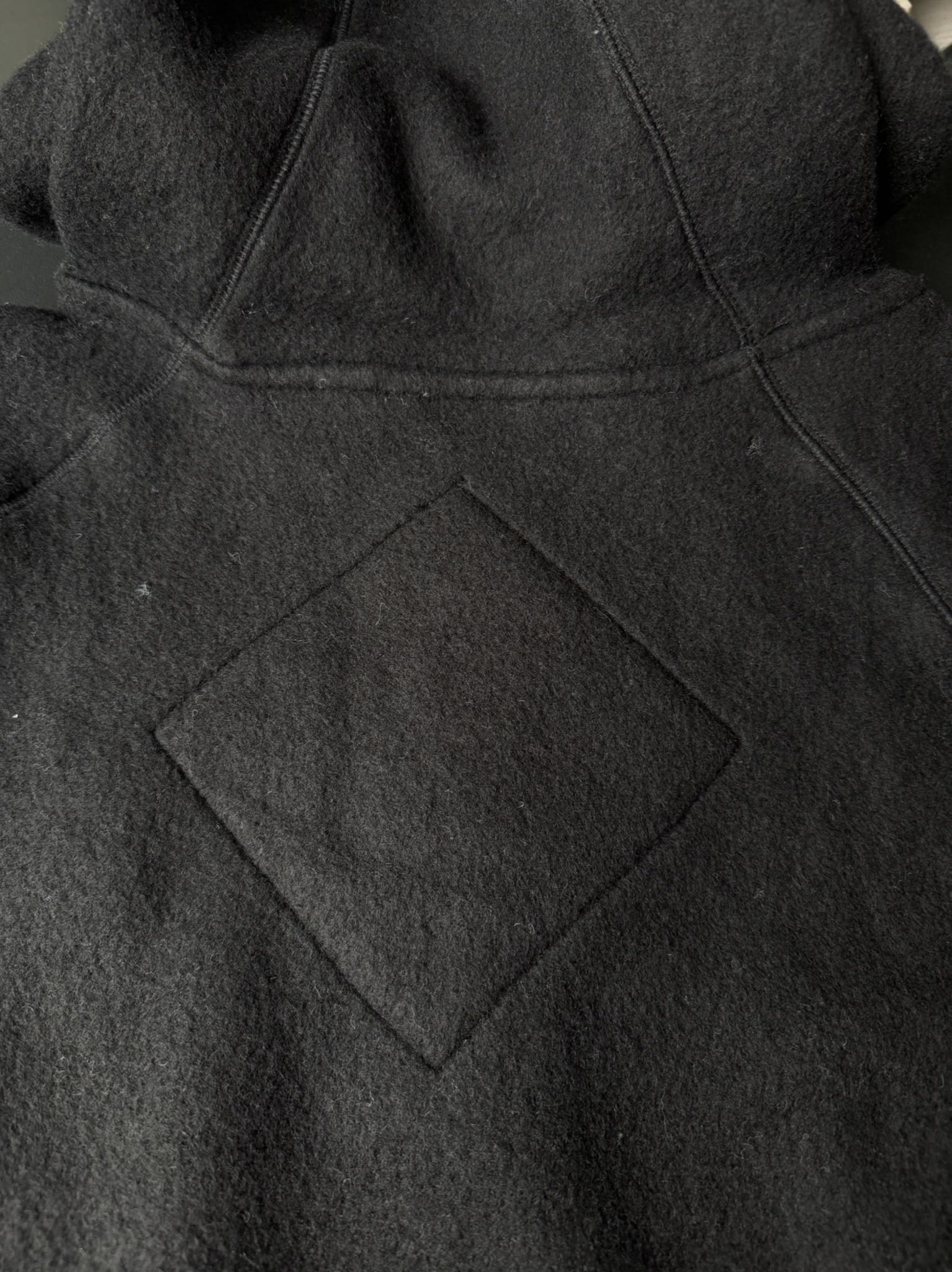 大鹅/Canada Goose抓绒羊毛饰章连帽夹克外套 面料选择: 以羊毛为主体，加入极少量氨纶和聚酯纤维混纺而成的羊毛抓绒面料。羊毛作为核心天然成分，提供无与伦比的温度调节、抑菌防臭和亲肤感。少量氨纶的喂入赋予了面料一定的四向弹性，日常活动时毫无束缚感。作为抓绒结构的基础，聚酯纤维增强了面料的耐久性、抗皱性和快干性，它构成了抓绒的蓬松感，并提供锁住空气等功能。 细节1: 衣袖和下摆采用2乘2罗纹收口，其强大的弹性，可以紧密贴合不同粗细的手腕和腰部，形成一个有效的&lsquo;密封&rsquo;,防止冷风倒灌。在多次拉伸和使用后仍能保持原有形状，不易松垮变形。且罗纹袖口能传递一种设计感，强化视觉美观度。 细节2: 兜帽设计与松紧扣的搭配提升穿戴时的保暖度与防风性能。 辅料:定制弹性抽绳松紧扣定制拉链吊坠定制臂章 尺码：S M L 颜色：黑 灰 咖 米 粉