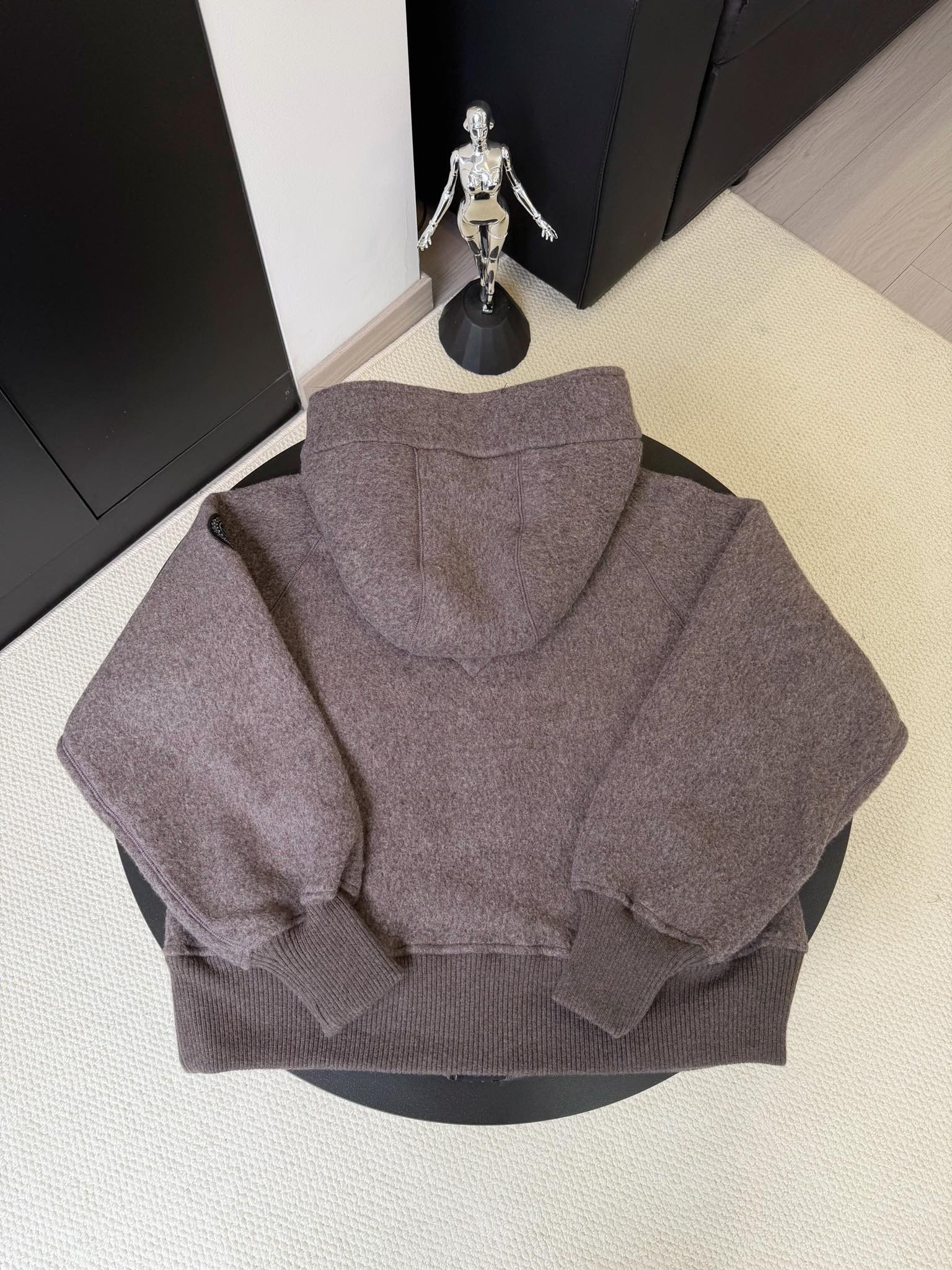 大鹅/Canada Goose抓绒羊毛饰章连帽夹克外套 面料选择: 以羊毛为主体，加入极少量氨纶和聚酯纤维混纺而成的羊毛抓绒面料。羊毛作为核心天然成分，提供无与伦比的温度调节、抑菌防臭和亲肤感。少量氨纶的喂入赋予了面料一定的四向弹性，日常活动时毫无束缚感。作为抓绒结构的基础，聚酯纤维增强了面料的耐久性、抗皱性和快干性，它构成了抓绒的蓬松感，并提供锁住空气等功能。 细节1: 衣袖和下摆采用2乘2罗纹收口，其强大的弹性，可以紧密贴合不同粗细的手腕和腰部，形成一个有效的&lsquo;密封&rsquo;,防止冷风倒灌。在多次拉伸和使用后仍能保持原有形状，不易松垮变形。且罗纹袖口能传递一种设计感，强化视觉美观度。 细节2: 兜帽设计与松紧扣的搭配提升穿戴时的保暖度与防风性能。 辅料:定制弹性抽绳松紧扣定制拉链吊坠定制臂章 尺码：S M L 颜色：黑 灰 咖 米 粉