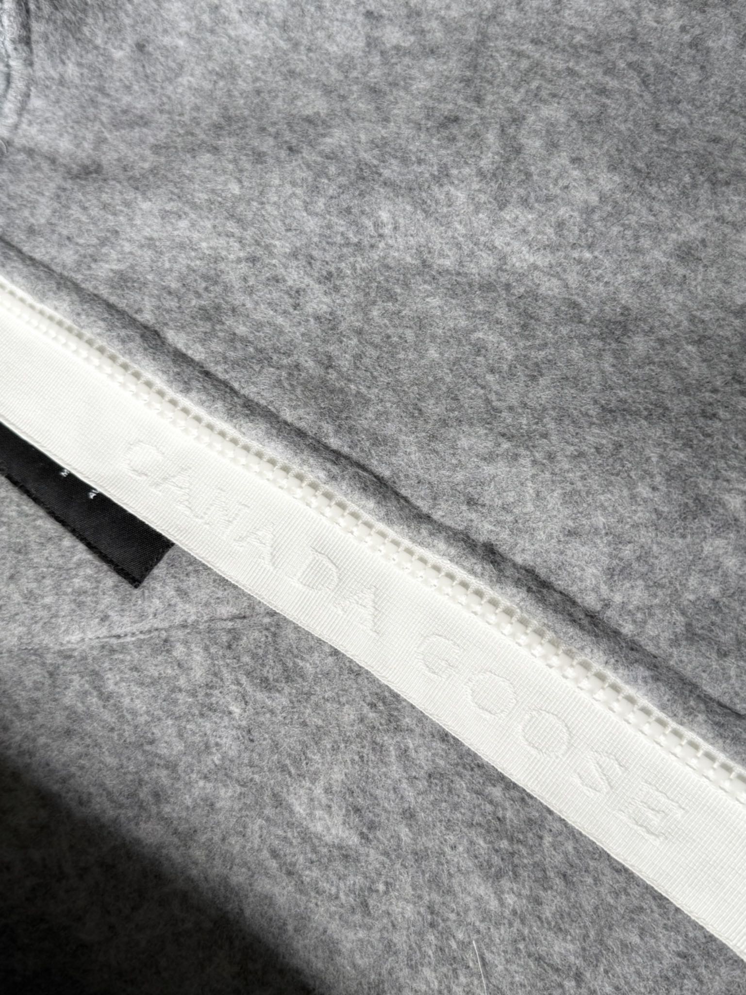 大鹅/Canada Goose抓绒羊毛饰章连帽夹克外套 面料选择: 以羊毛为主体，加入极少量氨纶和聚酯纤维混纺而成的羊毛抓绒面料。羊毛作为核心天然成分，提供无与伦比的温度调节、抑菌防臭和亲肤感。少量氨纶的喂入赋予了面料一定的四向弹性，日常活动时毫无束缚感。作为抓绒结构的基础，聚酯纤维增强了面料的耐久性、抗皱性和快干性，它构成了抓绒的蓬松感，并提供锁住空气等功能。 细节1: 衣袖和下摆采用2乘2罗纹收口，其强大的弹性，可以紧密贴合不同粗细的手腕和腰部，形成一个有效的&lsquo;密封&rsquo;,防止冷风倒灌。在多次拉伸和使用后仍能保持原有形状，不易松垮变形。且罗纹袖口能传递一种设计感，强化视觉美观度。 细节2: 兜帽设计与松紧扣的搭配提升穿戴时的保暖度与防风性能。 辅料:定制弹性抽绳松紧扣定制拉链吊坠定制臂章 尺码：S M L 颜色：黑 灰 咖 米 粉