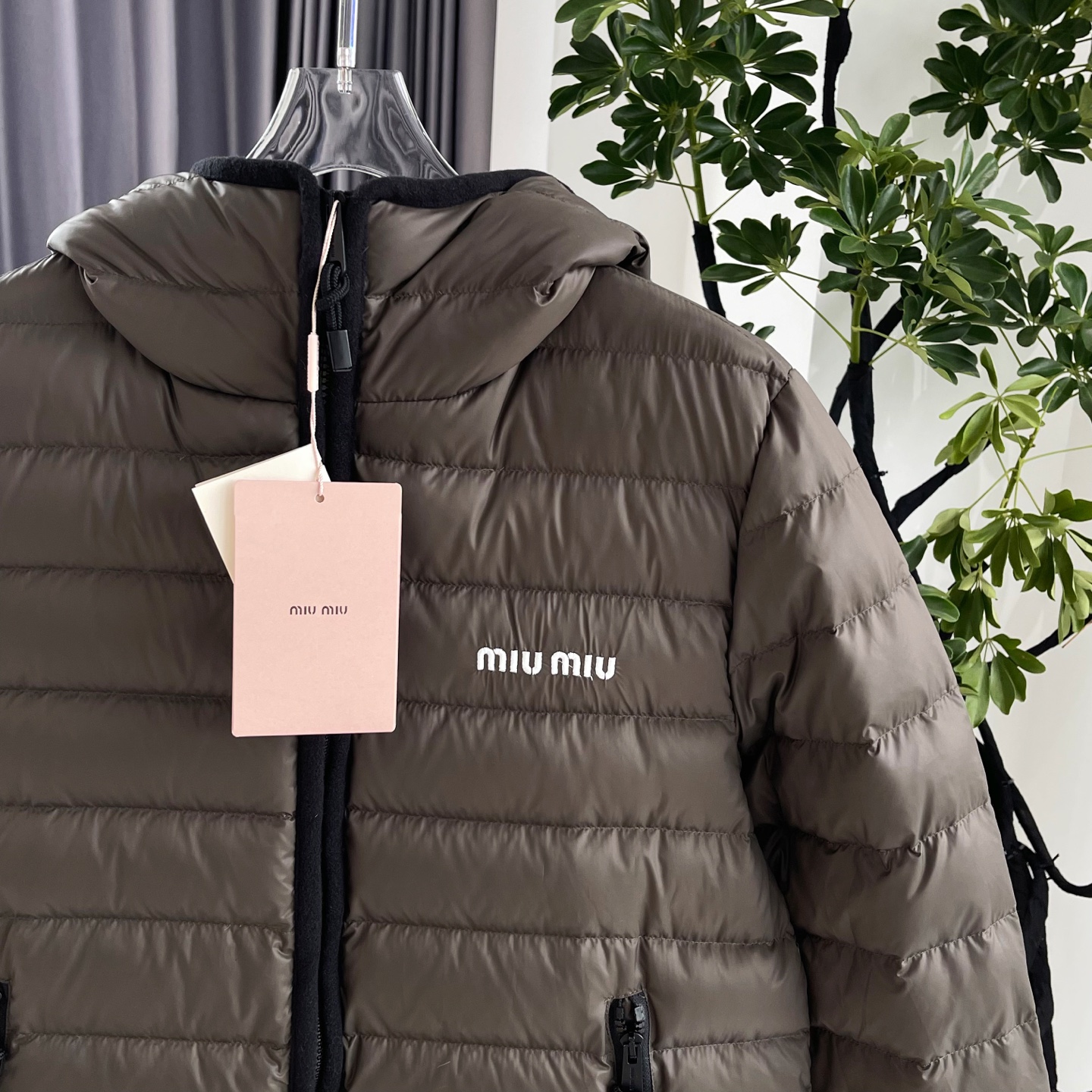 MiuMiu缪缪【冬日奢暖，型格兼备】 新款排骨连帽羽绒服外套女款 以简约轮廓勾勒高级气场。连帽设计与黑色抽绳细节，兼顾实用与时尚感。森林绿色与黑色羊绒包边撞色高级，增添层次感。左胸经典MIUMIU标志低调诠释品牌基因，优质羽绒填充锁住暖意。 无论是都市漫步还是休闲出行，皆能从容驾驭冬日氛围，赋予你温暖与风格并存的穿搭体验。 原版购入打版打色，开模定制五金辅料，三标齐全，1:1完美复刻。市面最高版！ 尺码：S/M/L