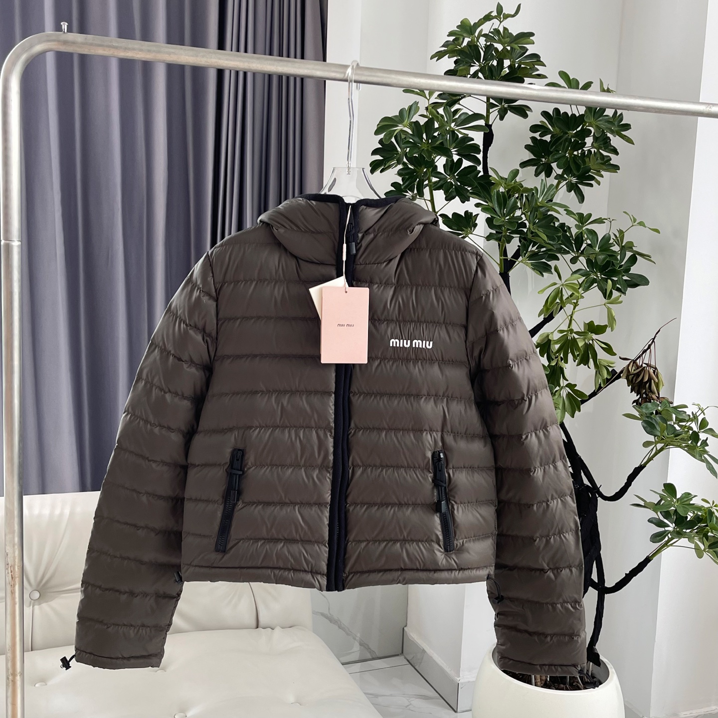 MiuMiu缪缪【冬日奢暖，型格兼备】 新款排骨连帽羽绒服外套女款 以简约轮廓勾勒高级气场。连帽设计与黑色抽绳细节，兼顾实用与时尚感。森林绿色与黑色羊绒包边撞色高级，增添层次感。左胸经典MIUMIU标志低调诠释品牌基因，优质羽绒填充锁住暖意。 无论是都市漫步还是休闲出行，皆能从容驾驭冬日氛围，赋予你温暖与风格并存的穿搭体验。 原版购入打版打色，开模定制五金辅料，三标齐全，1:1完美复刻。市面最高版！ 尺码：S/M/L