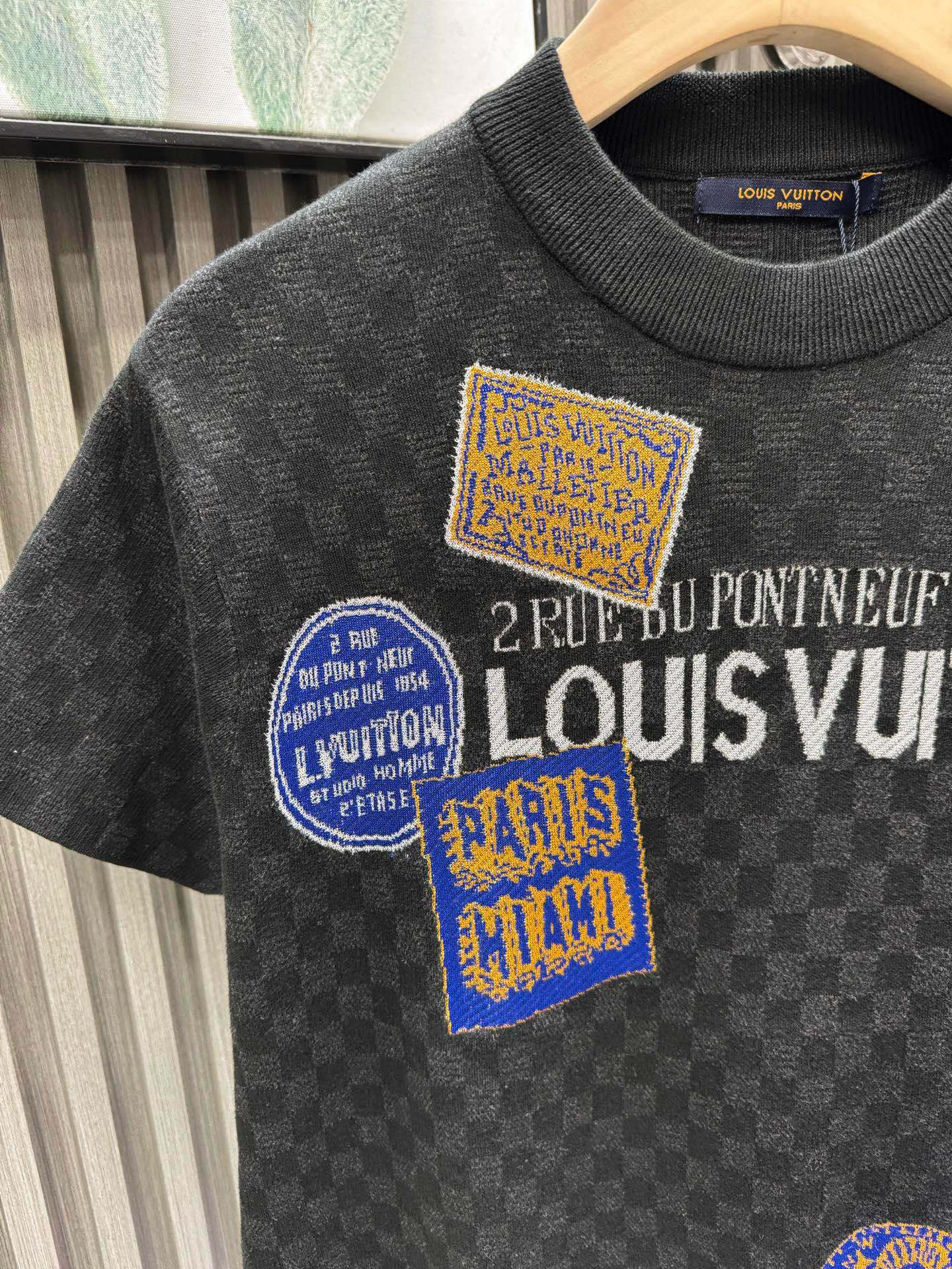 💰200🀄️ Louis Vuitton路易威登 LOUIS VUITTON 棋盘格标签针织短袖 采用定制棉质加光丝面料匠心制作 Damier提花嵌花织纹 德国进口挂毛机织片而成 织线原衣对色 环保固色定染 提花面料要求纱支精细衣身运用进口16针织令士提方格织法完美跟提花工艺每件耗时要150分钟 图案采取双面挂毛工艺 精细做工 肌理纹路清晰 极细织线由环保纤维打造 缝合采用的是16针盘 每个收口还要手工挑 缝线都要松紧一致要平顺 出品大身前后左右整齐对位理衣身面料具有软糯垂坠触感 面料舒适柔软 亲肤透气 富有弹性 全衣以棋盘格底纹 胸前品牌字母刺绣 配蓝色徽章设计感十足 和袖子均有品牌 细节做工精致 整体走线平直细腻 面料舒适柔软 颜色一致无色差 能与同款搭配营造时尚造型 三标齐全 男女同款