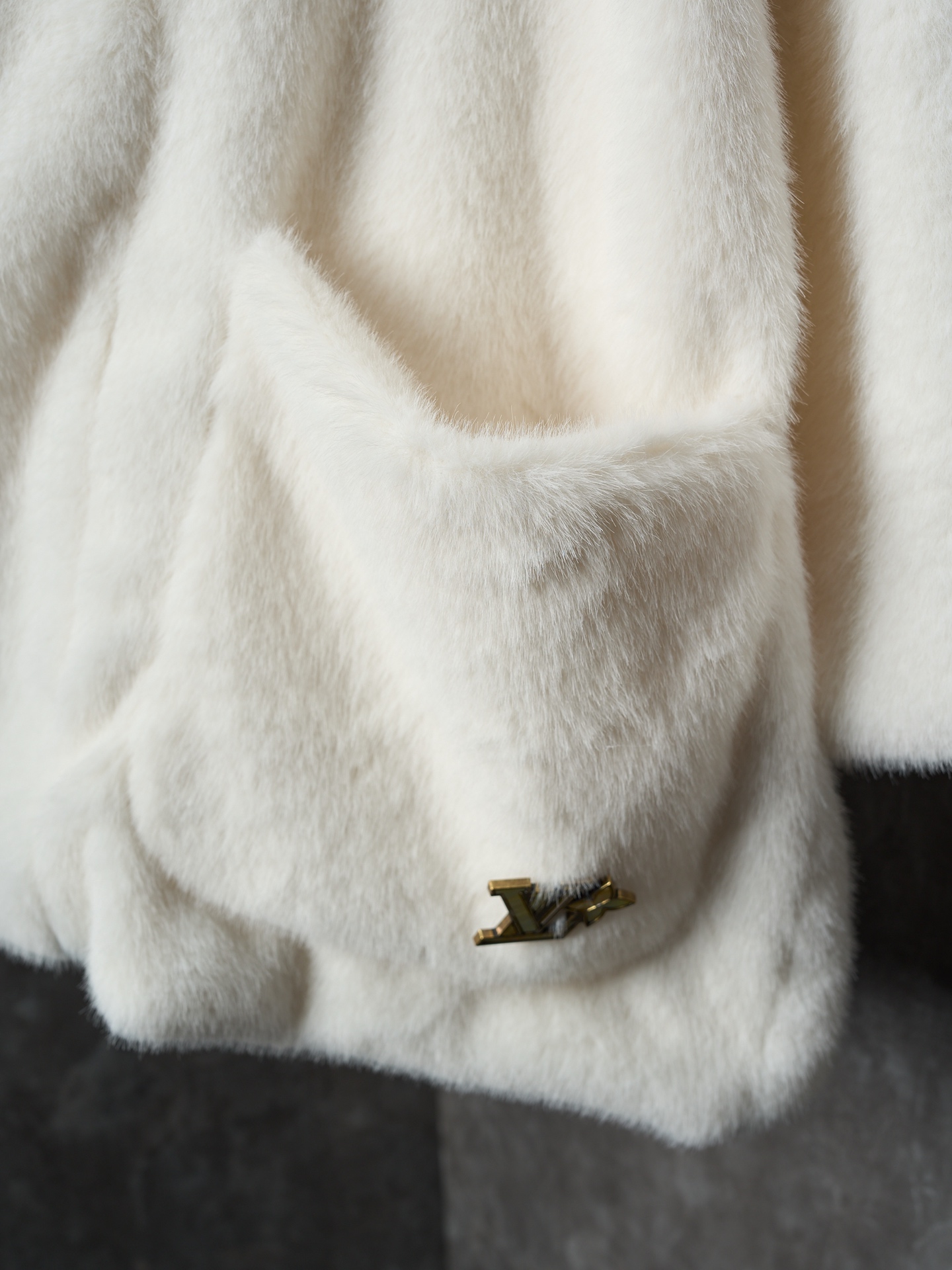 💰360【实物挂拍】LV/路易威登 Nigo联名系列水貂毛V领和服式皮草外套 【现货】46 48 50 52 面料选用北美优质水貂毛，经过手工分拣筛选，确保毛针长度、绒毛密度均匀一致，触感柔滑且光泽感强。剪裁采用无衬里极简结构，通过手工对缝拼接，避免车线痕迹破坏整体质感；领口做了宽幅翻折设计，边缘用隐形手工针脚收边，自然垂坠不生硬。袖口是同材质毛面翻边，内侧加了薄衬布定型，既保持蓬松感又不易变形；口袋为嵌式设计，开口边缘手工锁边，与衣身纹理无缝衔接。内里搭配品牌专属缎面衬里，标签通过定制挂链固定，细节处体现高定工艺标准。整体走线平直细腻，面料舒适柔软，颜色一致无色差 能与同款搭配营造时尚造型，驾驭各种场合，定制辅料，三标齐全，男女同款！