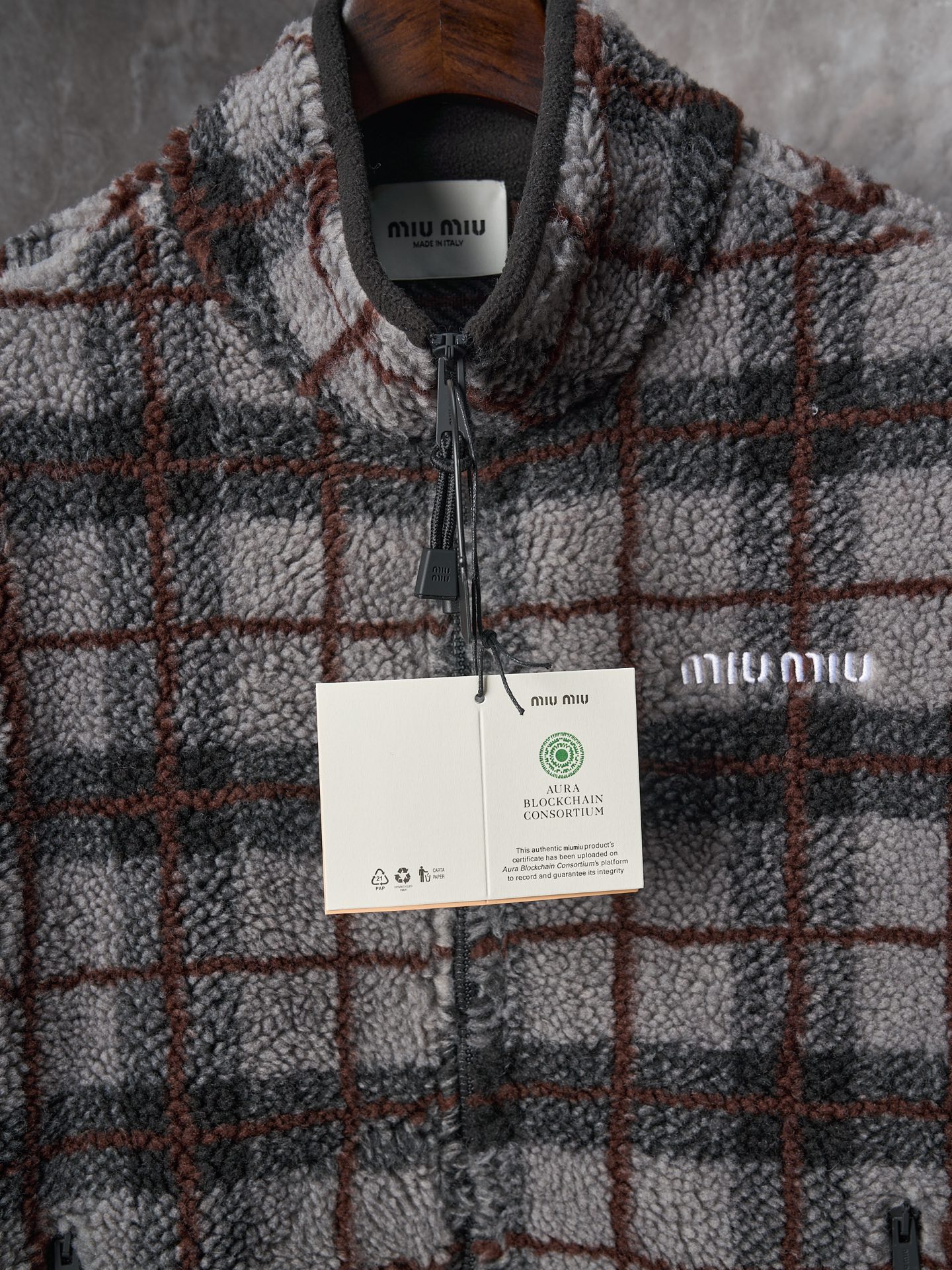 💰260【实物挂拍】MiuMiu/缪缪 羊羔绒格子刺绣拉链外套 【颜色】绿色 灰色 【现货】S M L XL 经典夹克在这款中被重新诠释，加入羊毛以增加厚度和柔软度。经典格纹图案汲取男装风格灵感，重新诠释运动女性气质的风格密码。 Oversize版型. 无衬里长袖立领.正面拉链开合 侧袋.双头钩针底边.刺绣徽标 采用80%羊毛，20%棉。该款面料原版定织定染，100%还原。内衬口袋布采用100%尼龙料， 后领位置搭配100%羊毛泰迪绒。 拉链采用尼龙与胶牙材料结合，拉牙采用欧款胶牙。下摆搭配原版刻字弹力扣。 刺绣采用3D立体刺绣工艺，刺绣logo饱满立体。呈现出高端视觉效果。