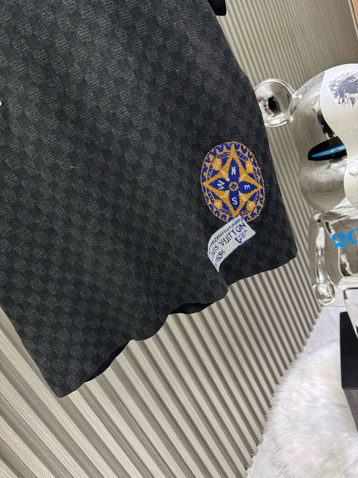 💰200🀄️ Louis Vuitton路易威登 LOUIS VUITTON 棋盘格标签针织短袖 采用定制棉质加光丝面料匠心制作 Damier提花嵌花织纹 德国进口挂毛机织片而成 织线原衣对色 环保固色定染 提花面料要求纱支精细衣身运用进口16针织令士提方格织法完美跟提花工艺每件耗时要150分钟 图案采取双面挂毛工艺 精细做工 肌理纹路清晰 极细织线由环保纤维打造 缝合采用的是16针盘 每个收口还要手工挑 缝线都要松紧一致要平顺 出品大身前后左右整齐对位理衣身面料具有软糯垂坠触感 面料舒适柔软 亲肤透气 富有弹性 全衣以棋盘格底纹 胸前品牌字母刺绣 配蓝色徽章设计感十足 和袖子均有品牌 细节做工精致 整体走线平直细腻 面料舒适柔软 颜色一致无色差 能与同款搭配营造时尚造型 三标齐全 男女同款