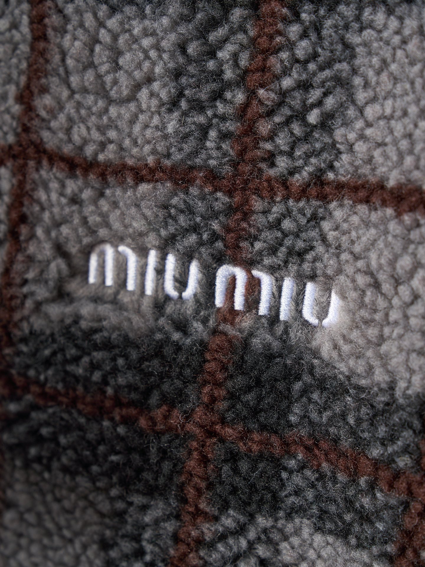 💰260【实物挂拍】MiuMiu/缪缪 羊羔绒格子刺绣拉链外套 【颜色】绿色 灰色 【现货】S M L XL 经典夹克在这款中被重新诠释，加入羊毛以增加厚度和柔软度。经典格纹图案汲取男装风格灵感，重新诠释运动女性气质的风格密码。 Oversize版型. 无衬里长袖立领.正面拉链开合 侧袋.双头钩针底边.刺绣徽标 采用80%羊毛，20%棉。该款面料原版定织定染，100%还原。内衬口袋布采用100%尼龙料， 后领位置搭配100%羊毛泰迪绒。 拉链采用尼龙与胶牙材料结合，拉牙采用欧款胶牙。下摆搭配原版刻字弹力扣。 刺绣采用3D立体刺绣工艺，刺绣logo饱满立体。呈现出高端视觉效果。