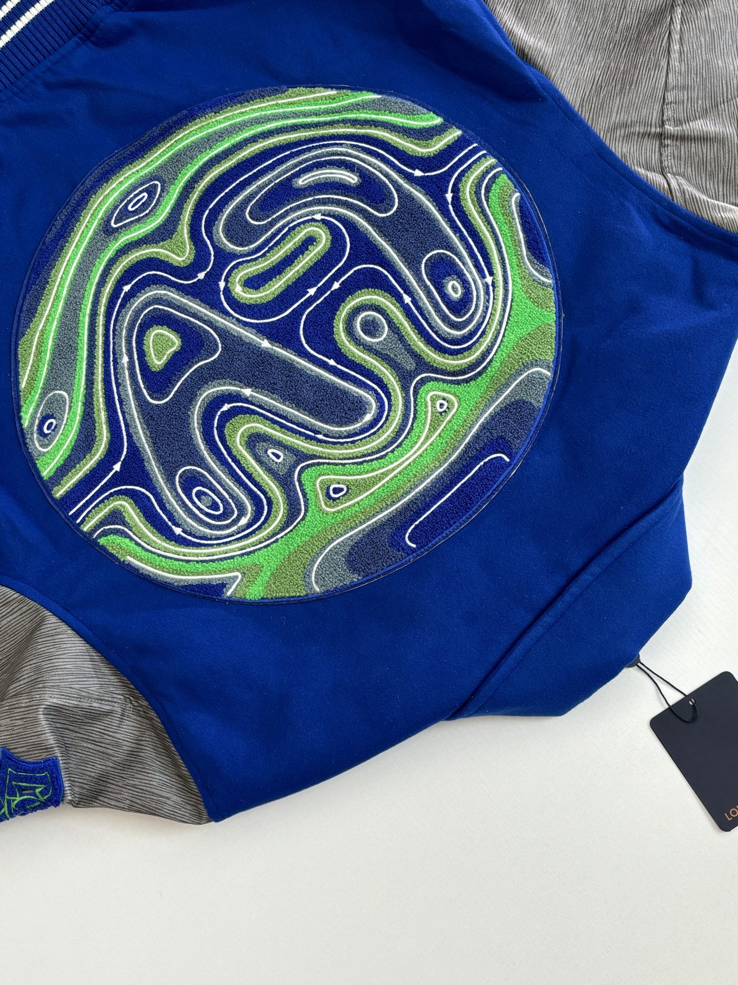 P410 1V/路易 FW23 毛巾绣花棒球服外套 面料成分有65%的羊毛，15%天然丝，10%的氨纶，10%绒混合定织而成，总的克重有900多克，还有最为关键的是色牢度，牢固不会褪色，袖子用的进口粒面皮质，加工定型，上色，水洗，纹路保留了原有的颗粒结构，厚实饱满圆润，刺绣使用进口毛巾绣机器，先把每个图案绣在毛毡上，在用红外线激光雕刻出来，再有缝纫机进行固定，这件衣服有多处贴标，一处平绣，后身的大图案是直接绣在上面的，这款衣服有4种不同工艺的绣花，螺纹采用全棉纱线定染定织而成，粗纱横机编织而成，不起球，棉质亲肤，立体感十足，定制辅料三标，洗涤建议首选干洗，次选手洗或者轻柔机洗，机洗请单独单件套洗衣袋轻柔机洗，不能烘干和热水洗涤，不能长时间浸泡暴晒，正确的洗涤方式可使衣服使用寿命延长 Size：S/M/L/XL