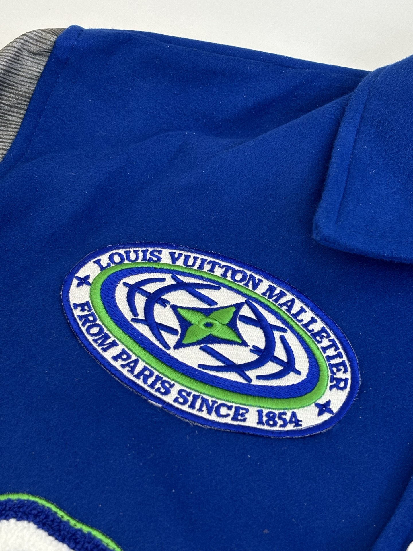 P410 1V/路易 FW23 毛巾绣花棒球服外套 面料成分有65%的羊毛，15%天然丝，10%的氨纶，10%绒混合定织而成，总的克重有900多克，还有最为关键的是色牢度，牢固不会褪色，袖子用的进口粒面皮质，加工定型，上色，水洗，纹路保留了原有的颗粒结构，厚实饱满圆润，刺绣使用进口毛巾绣机器，先把每个图案绣在毛毡上，在用红外线激光雕刻出来，再有缝纫机进行固定，这件衣服有多处贴标，一处平绣，后身的大图案是直接绣在上面的，这款衣服有4种不同工艺的绣花，螺纹采用全棉纱线定染定织而成，粗纱横机编织而成，不起球，棉质亲肤，立体感十足，定制辅料三标，洗涤建议首选干洗，次选手洗或者轻柔机洗，机洗请单独单件套洗衣袋轻柔机洗，不能烘干和热水洗涤，不能长时间浸泡暴晒，正确的洗涤方式可使衣服使用寿命延长 Size：S/M/L/XL