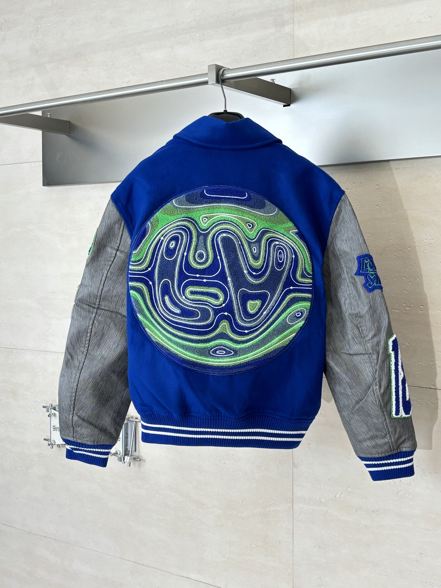 P410 1V/路易 FW23 毛巾绣花棒球服外套 面料成分有65%的羊毛，15%天然丝，10%的氨纶，10%绒混合定织而成，总的克重有900多克，还有最为关键的是色牢度，牢固不会褪色，袖子用的进口粒面皮质，加工定型，上色，水洗，纹路保留了原有的颗粒结构，厚实饱满圆润，刺绣使用进口毛巾绣机器，先把每个图案绣在毛毡上，在用红外线激光雕刻出来，再有缝纫机进行固定，这件衣服有多处贴标，一处平绣，后身的大图案是直接绣在上面的，这款衣服有4种不同工艺的绣花，螺纹采用全棉纱线定染定织而成，粗纱横机编织而成，不起球，棉质亲肤，立体感十足，定制辅料三标，洗涤建议首选干洗，次选手洗或者轻柔机洗，机洗请单独单件套洗衣袋轻柔机洗，不能烘干和热水洗涤，不能长时间浸泡暴晒，正确的洗涤方式可使衣服使用寿命延长 Size：S/M/L/XL