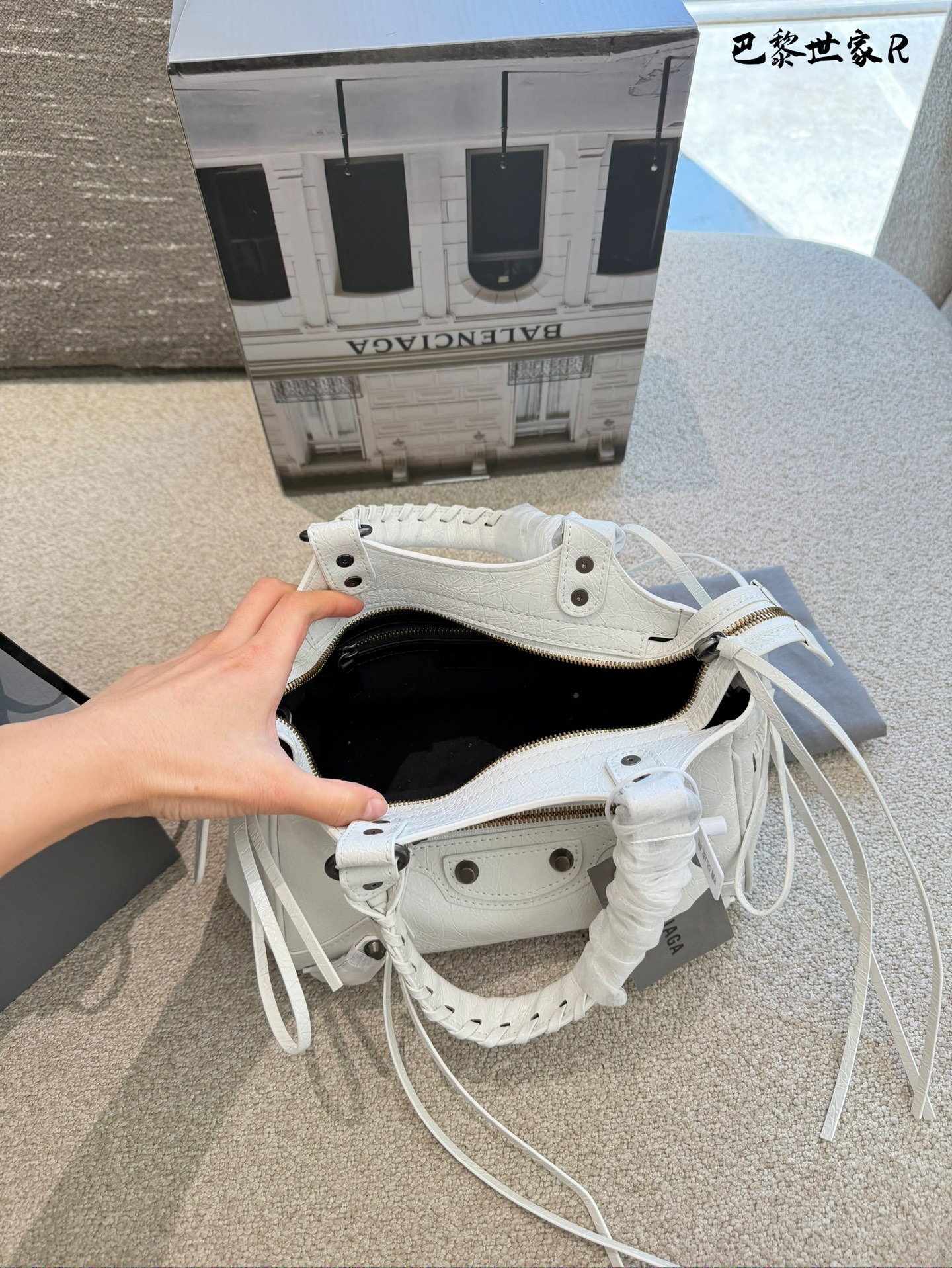 巴黎世家机车包p250 这是巴黎世家机车包，属于时尚界的经典单品。包身采用油蜡皮材质，配有铆钉装饰，设计硬朗且富有质感。常见尺寸有mini、小号和中号，适合不同身高和需求的人 群。原产地为法国，是巴黎世家品牌的标志性产品之一- ,深受全球时尚爱好者的喜爱。 养护方面，建议避免长时间暴露在阳光下，以免褪色。使用后及时清理表面灰尘，可用柔软布料轻轻擦拭。定期检查五金件是否松动，必要时可联系专业维修服务进行维护23cm