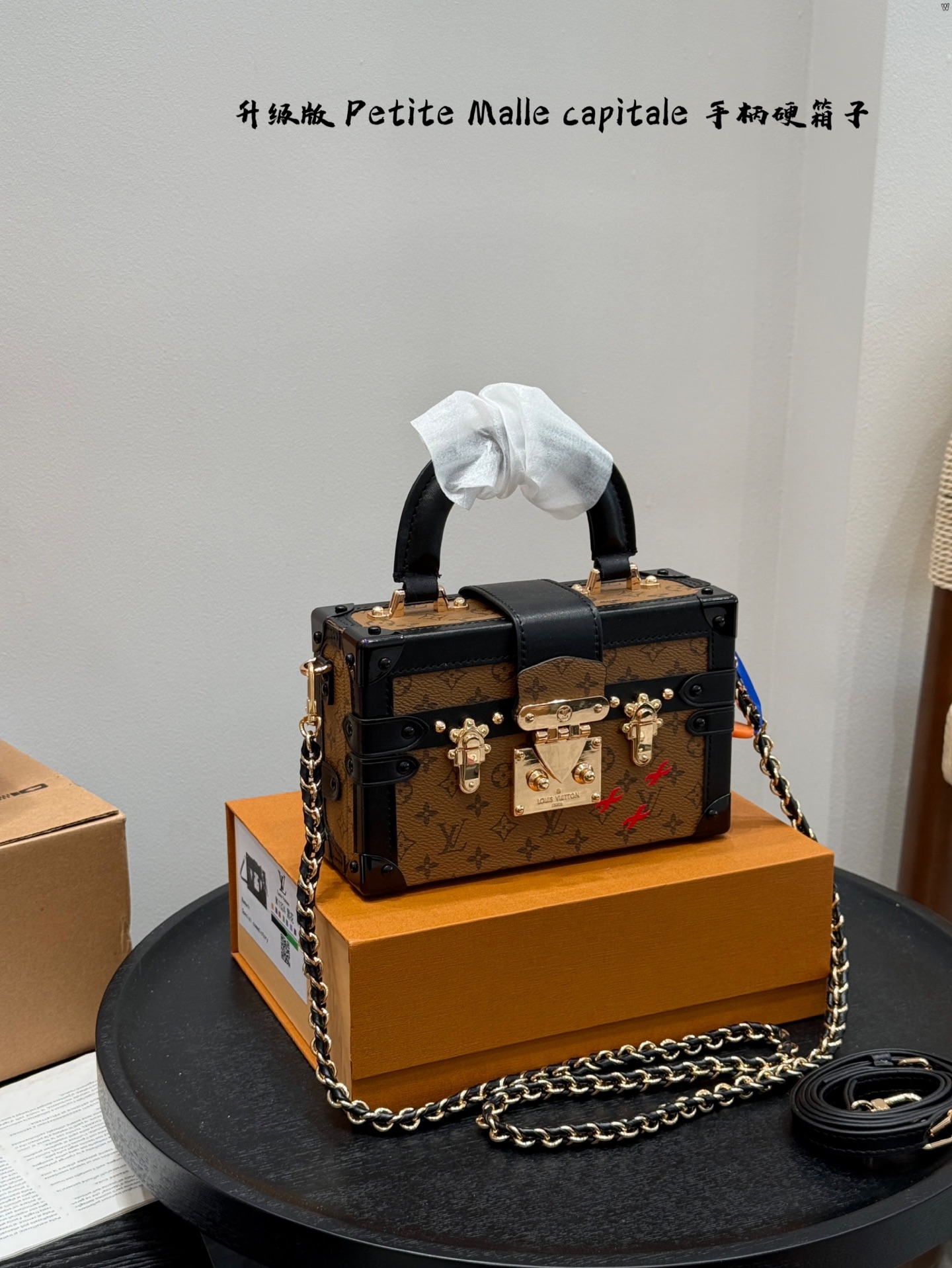 p185 礼盒包装 升级版！ size：19*12cm Lv 秀款Petite Malle capitale手提手柄盒子新款 手提硬箱 跟以往的小箱子设计外形一样，新款只是增加手提把手， 缓缓流露复古气息。 既时尚又实用，它是一款多功能包，轻巧易用，允许多种携带方式：手拎、肩扛和斜挎。