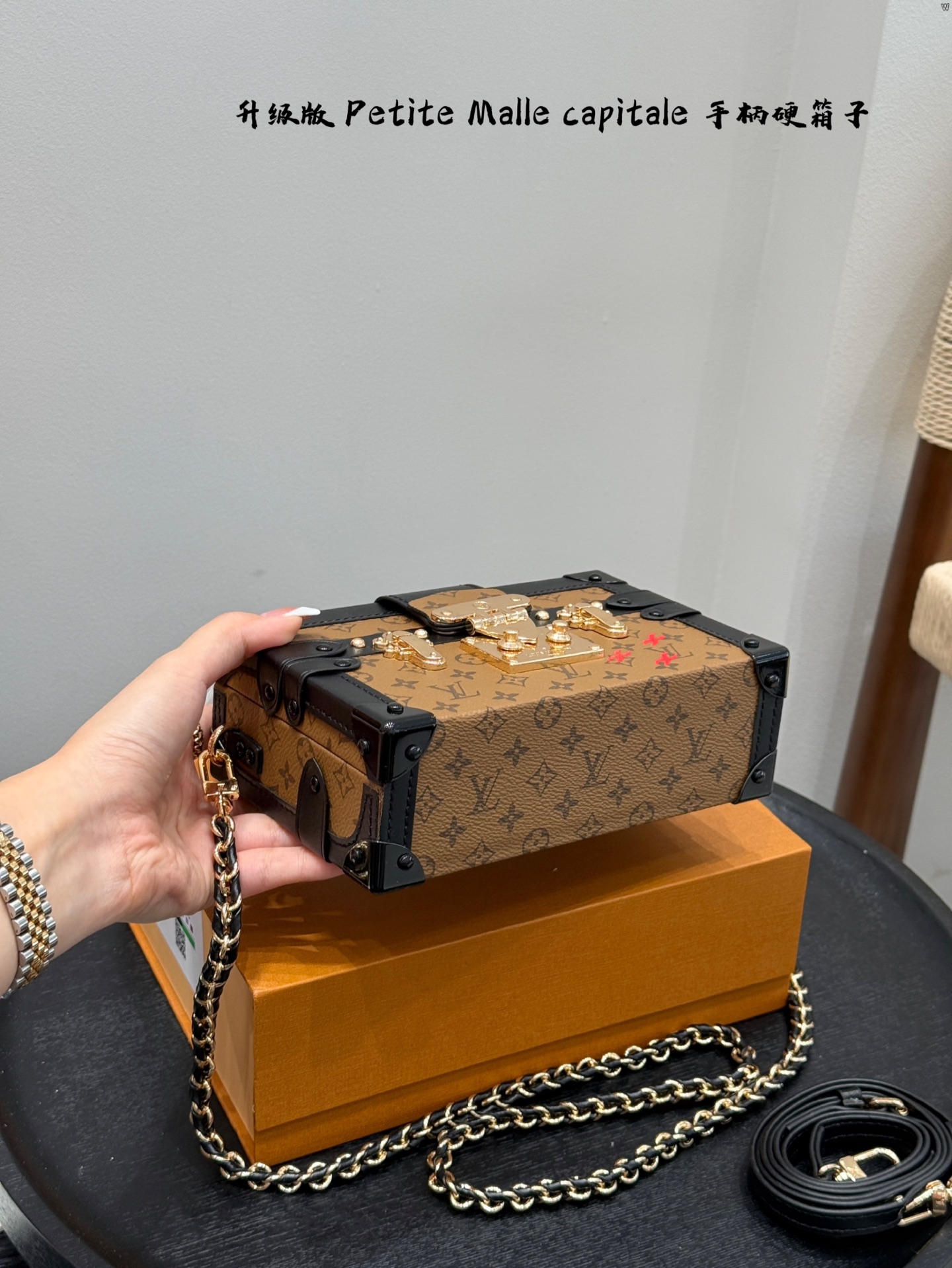 p185 礼盒包装 升级版！ size：19*12cm Lv 秀款Petite Malle capitale手提手柄盒子新款 手提硬箱 跟以往的小箱子设计外形一样，新款只是增加手提把手， 缓缓流露复古气息。 既时尚又实用，它是一款多功能包，轻巧易用，允许多种携带方式：手拎、肩扛和斜挎。