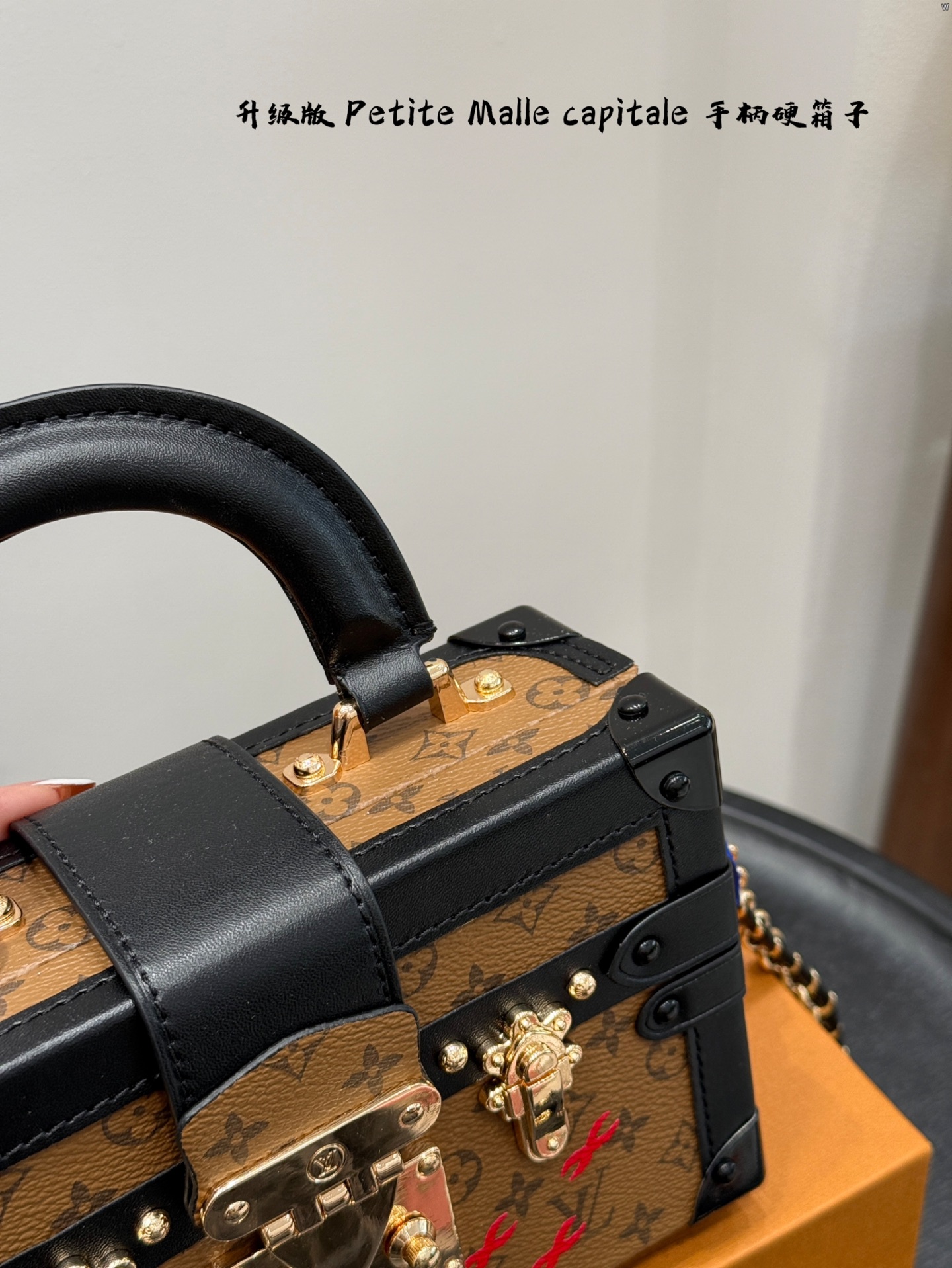 p185 礼盒包装 升级版！ size：19*12cm Lv 秀款Petite Malle capitale手提手柄盒子新款 手提硬箱 跟以往的小箱子设计外形一样，新款只是增加手提把手， 缓缓流露复古气息。 既时尚又实用，它是一款多功能包，轻巧易用，允许多种携带方式：手拎、肩扛和斜挎。