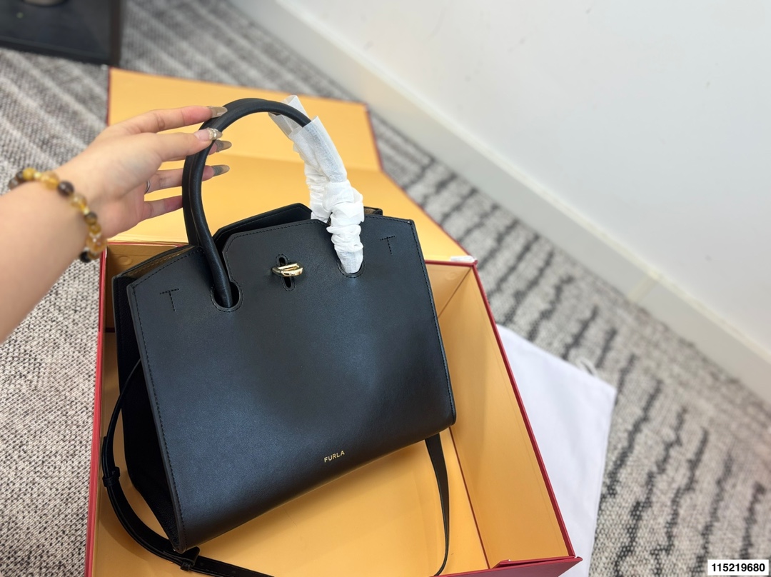 P180配折叠盒⚠️尺寸29.25 Furla Genesi托特包 选用优质牛皮,表面光滑有型,立体剪裁让包内空问更宽敞。金色半圆扭扣+压印Logo,细节满分!尺寸适中,通勤休闲都OK,手提斜挎随心切换。黑色百搭,四季都能用,简约大气,实用又有质感,是职场女生的理想选择