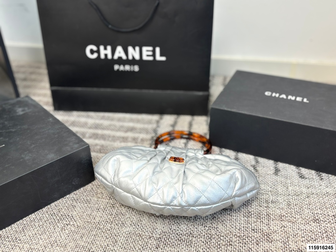 p145 配折叠盒 Chanel 26C玳瑁手柄福袋包 Chanel 26C早春系列福袋包，黑色麂皮+玳瑁色手柄，复古优雅感满满十。经典菱格纹缝线+双CLogo，细节超精致，手机小物轻松收纳，麂皮柔软，秋冬搭配超有氛围感 。玳瑁手柄光泽感强，手提或复古风都很出彩，实用又时髦，是热门单品！ 尺寸 30.20