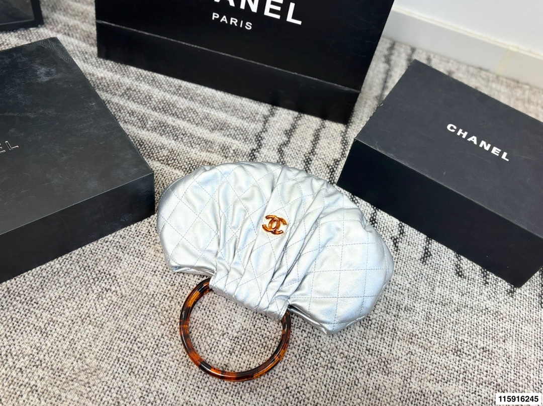 p145 配折叠盒 Chanel 26C玳瑁手柄福袋包 Chanel 26C早春系列福袋包，黑色麂皮+玳瑁色手柄，复古优雅感满满十。经典菱格纹缝线+双CLogo，细节超精致，手机小物轻松收纳，麂皮柔软，秋冬搭配超有氛围感 。玳瑁手柄光泽感强，手提或复古风都很出彩，实用又时髦，是热门单品！ 尺寸 30.20