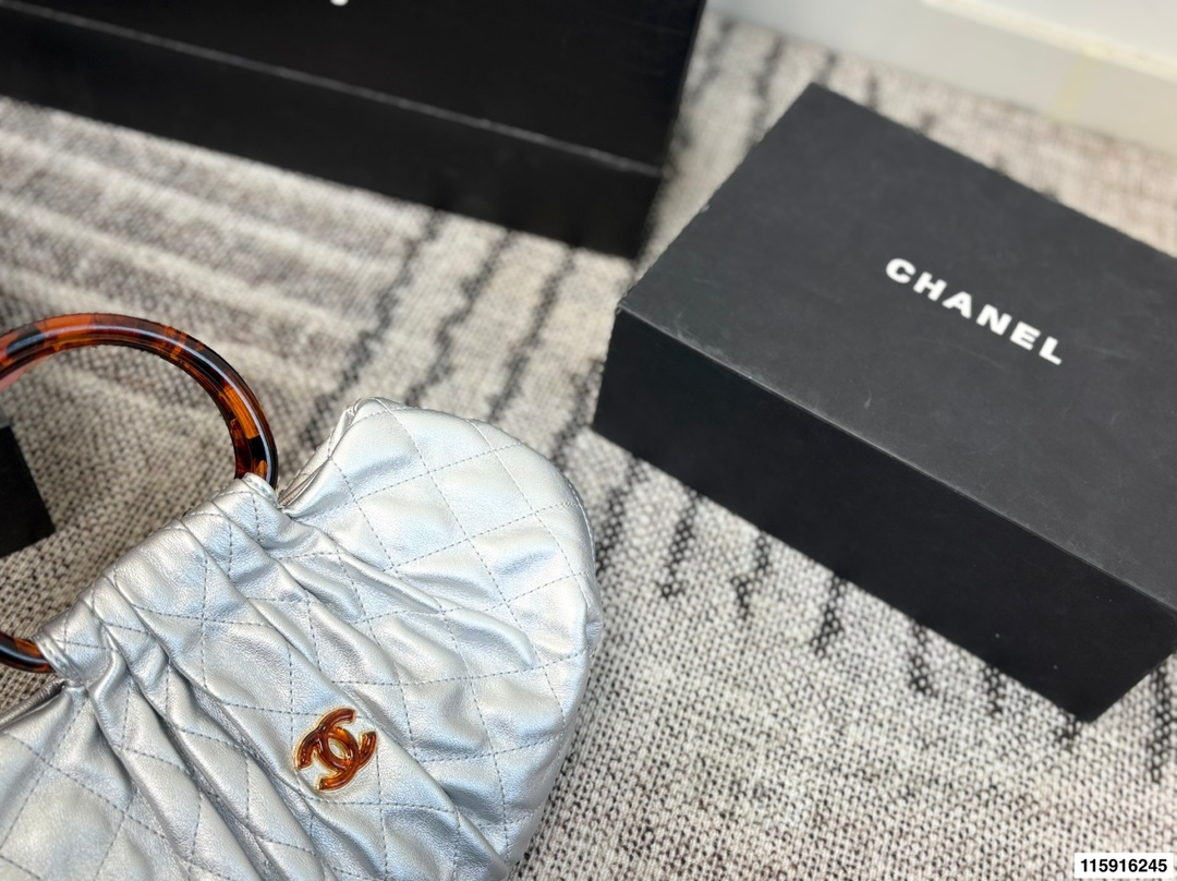 p145 配折叠盒 Chanel 26C玳瑁手柄福袋包 Chanel 26C早春系列福袋包，黑色麂皮+玳瑁色手柄，复古优雅感满满十。经典菱格纹缝线+双CLogo，细节超精致，手机小物轻松收纳，麂皮柔软，秋冬搭配超有氛围感 。玳瑁手柄光泽感强，手提或复古风都很出彩，实用又时髦，是热门单品！ 尺寸 30.20