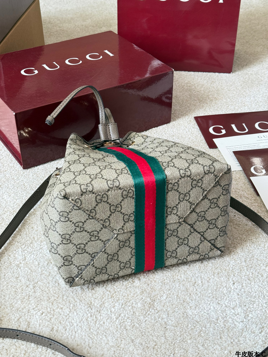 牛皮版本 p165 Gucci Ophidia 老花水桶包 Gucci Ophidia系列老花水桶包，采用米色/乌木色GGSupreme涂层帆布，搭配棕色皮革滚边和黄铜金属配件，复古又时髦！正面双G金属Logo+红绿织带，品牌辨识度超高。尺寸约20x22&times;14cm，抽绳开合，内部有开放式口袋和手机袋，日常通勤、休闲出行都很实用。肩带可调节，手拎、单肩、斜挎、双肩多种背法，百搭灵活，是Gucci经典热门款！