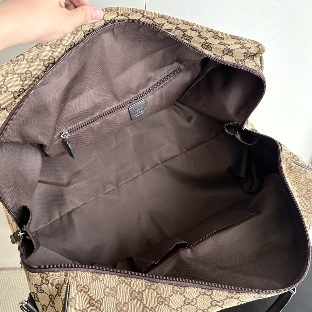 实拍#💰280 款号：802095 尺寸：45/28/24cm 秋冬男士系列经典旅行单品生动展现运动风格。该系列旅行单品采用OriginalGG帆布制作，经典配饰搭配甄选配色，织带和压花标识等精致细节传递时尚气息。这款旅行包以米色和乌木色帆布打造，搭配一个外部口袋、顶部提手和D形环。