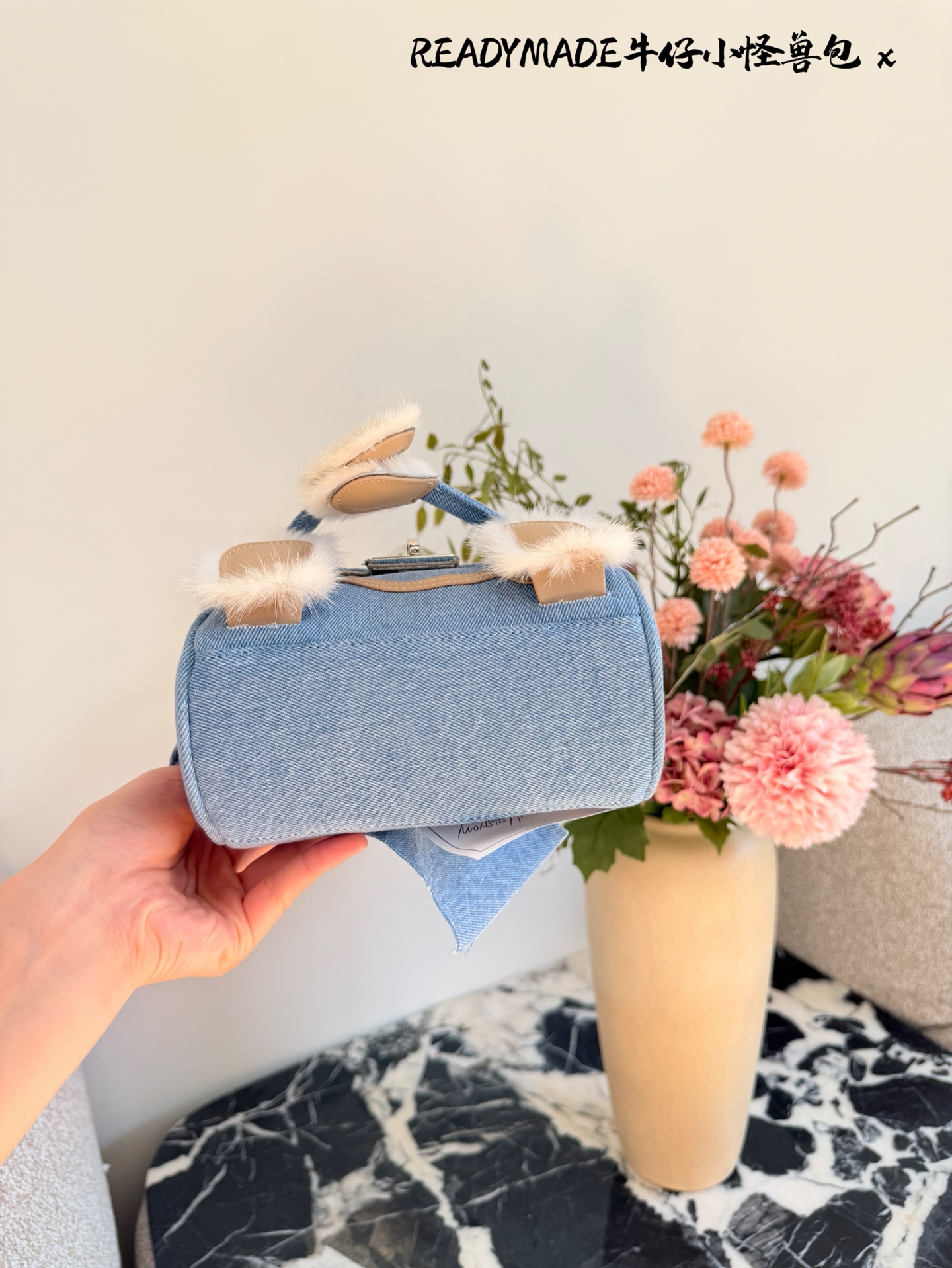 p215 READYMADE牛仔小怪兽包 国日本小众品牌READYMADE的牛仔小怪兽包，灵感来 自爱马仕Kelly Doll,浅蓝牛仔布+貂毛手脚，手感超柔软，趣味满分汁。迷你尺寸约18cm，能装手机、气垫等日常小物，手拎斜挎都OK，街头风、甜酷风都能轻松驾驭!部分配色已停产，收藏价值高，超适合喜欢个性和可爱风的姐妹们。