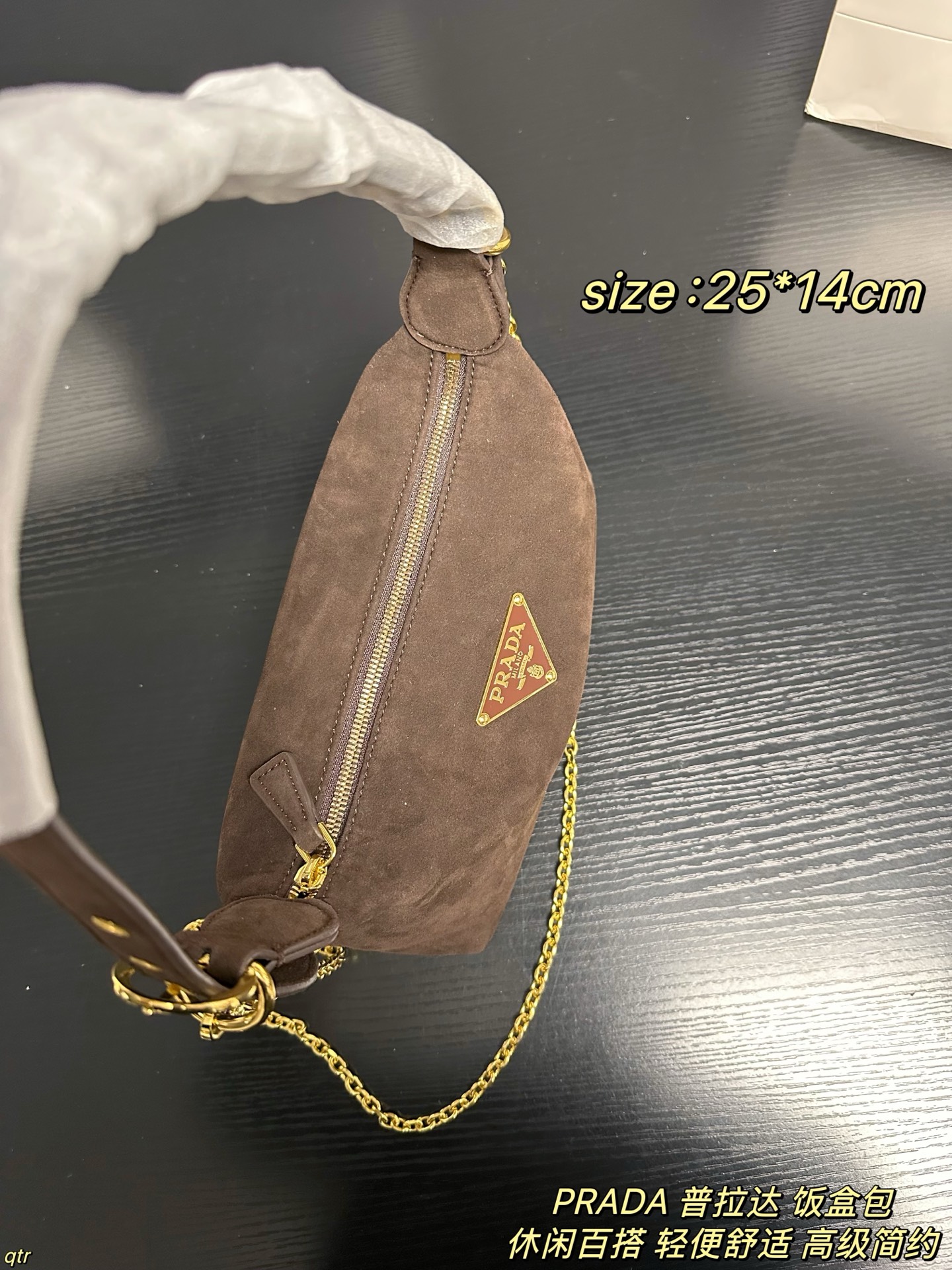 P105配盒 PRADA 普拉达 饭盒包 这款包采用进口麂皮，具有柔软的轮廓和多个口袋，轻质实用的Re-Nylon强调了设计的多功能风格，而皮革细节和标志性点缀则反映了Prada的手工传统，配有2条可拆卸、可调节的编织标志带肩带，容量空间大，上身效果非常时尚。又是一款永久不过时爆款。值得拥有 尺寸：25*14cm