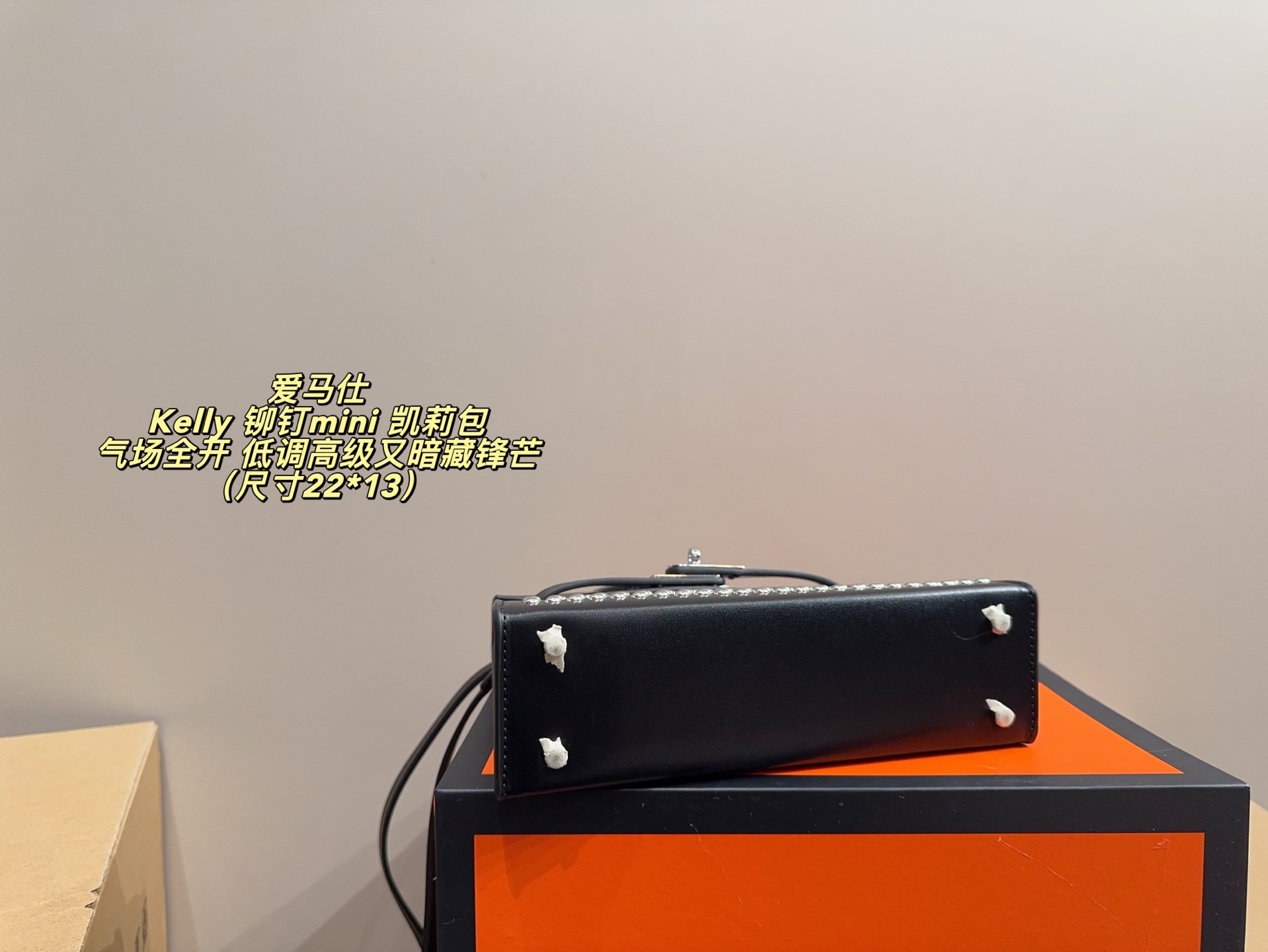 P150 无盒配布袋⚠️尺寸22*13 爱马仕 Kelly 铆钉mini 凯莉包 经典的Box小牛皮，包身加入了117颗纯手工手打钉，仔细看每颗钉子都能看出有敲打的痕迹，珠宝级打磨，每颗窝钉都圆润饱满。让整个包瞬间摇滚风拉满，再加上银扣的清冷，简直气场全开。黑银的确是更酷的配色，黑武士的既视感，低调高级又暗藏锋芒。目前黑银的热度远超黑金，金棕等经典配色。只要喜欢，就大胆拿下！