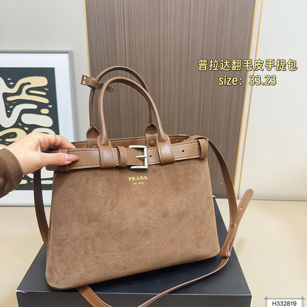 💰235 配盒⚠️尺寸33*23 Prada 普拉达 Buckle翻毛皮手提包 2024春夏系列，采用柔软麂皮，触感细腻，低调哑光质感超有氛围感。标志性金属腰带＋三角徽标，辨识度满分！尺寸适中中，通勤休闲都能轻松驾驱。肩带可拆卸调节，手提斜挎随心切换，实用又时髦。简约大气，时尚爱好者必入！