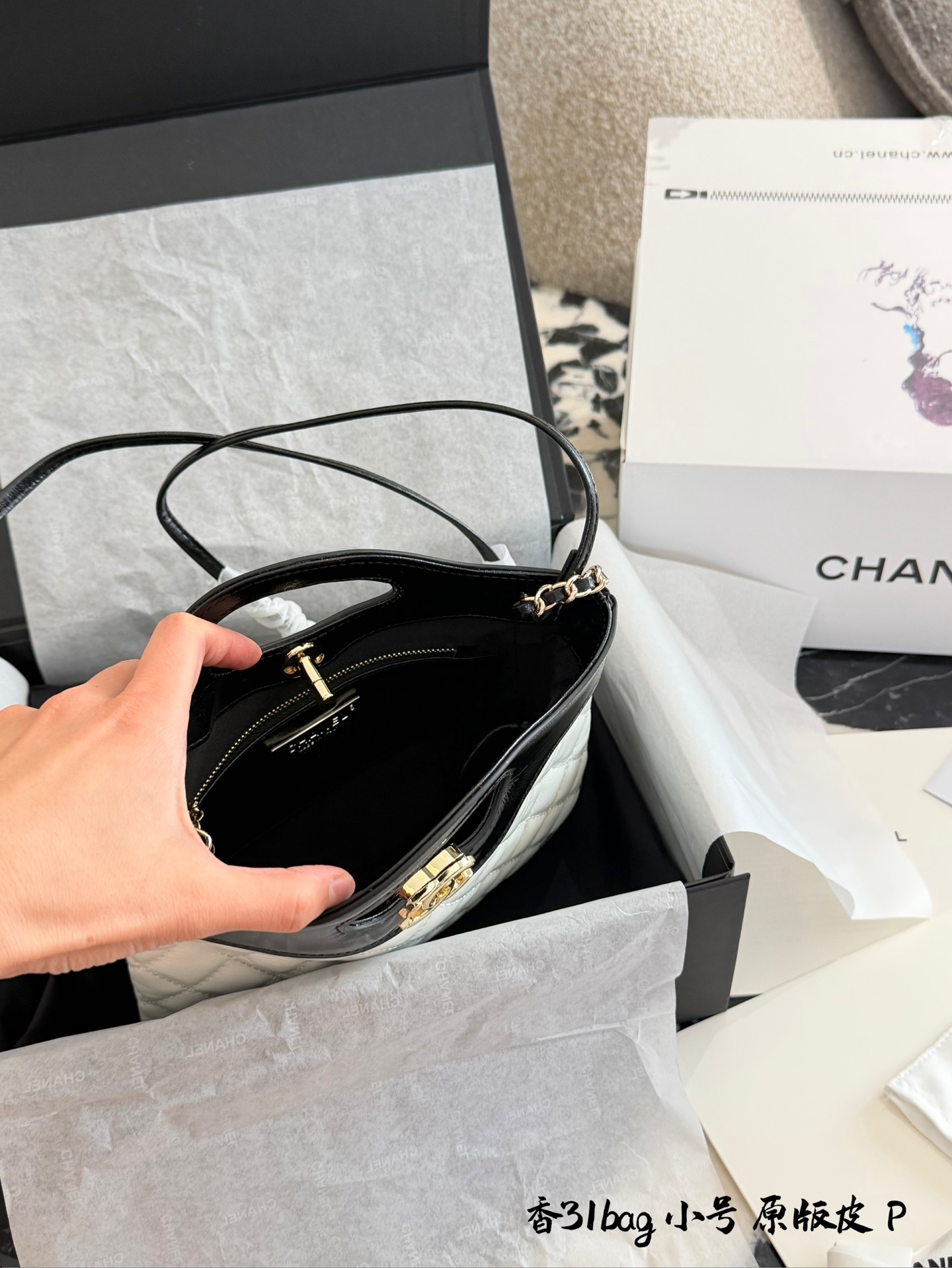 p200 香奈儿Mini31Bag熊猫色 牛皮 Q3香奈儿Mini 31 Bag熊猫色，黑白拼接超经典，漆皮+菱格纹设计，淡金色五金超有质感十。22x23x5.5cm 22x23x5.5cm，小巧精致，手提or斜挎都OK，链条肩带多种背法随心切换!旋钮扣设计更安全，容量虽小但手机钥匙都能装下，通勤出行都很适合。复古时髦，百搭不挑人，是香奈儿热门爆款之一!