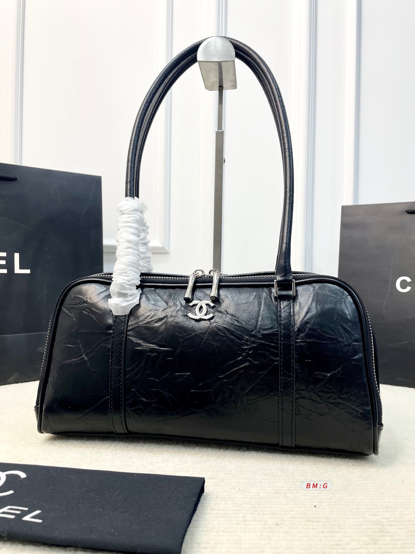 💰225 香奈儿黑色油蜡皮保龄球包，经典弧形设计，油蜡皮自带褶皱纹理，复古又高级✨。正面金属双C Logo超有辨识度，拉链开合更安全。内部空间合理，通勤休闲都能装。手柄弧形，手提肩背都OK，实用又时髦。 尺寸：31*9*16.5