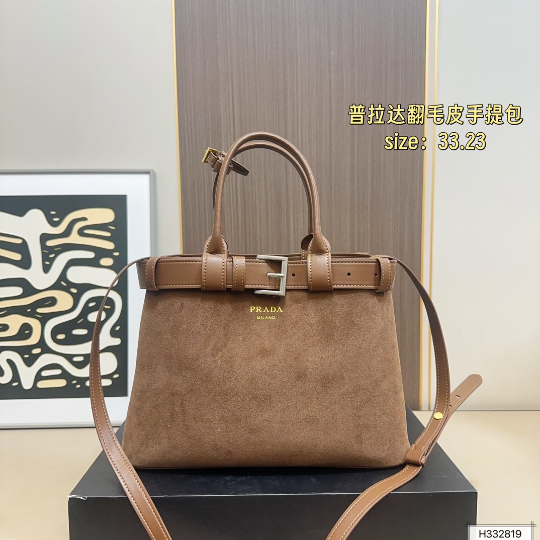 💰235 配盒⚠️尺寸33*23 Prada 普拉达 Buckle翻毛皮手提包 2024春夏系列，采用柔软麂皮，触感细腻，低调哑光质感超有氛围感。标志性金属腰带＋三角徽标，辨识度满分！尺寸适中中，通勤休闲都能轻松驾驱。肩带可拆卸调节，手提斜挎随心切换，实用又时髦。简约大气，时尚爱好者必入！