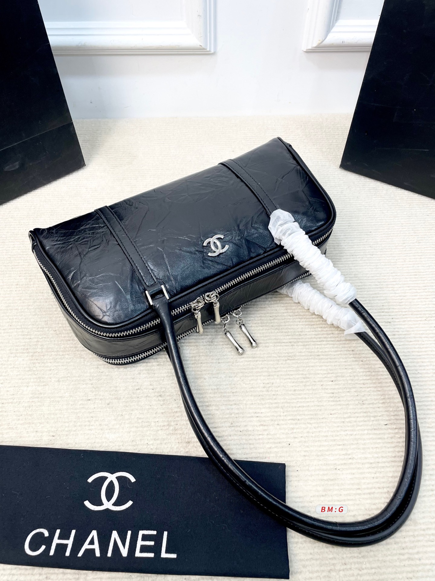 💰225 香奈儿黑色油蜡皮保龄球包，经典弧形设计，油蜡皮自带褶皱纹理，复古又高级✨。正面金属双C Logo超有辨识度，拉链开合更安全。内部空间合理，通勤休闲都能装。手柄弧形，手提肩背都OK，实用又时髦。 尺寸：31*9*16.5