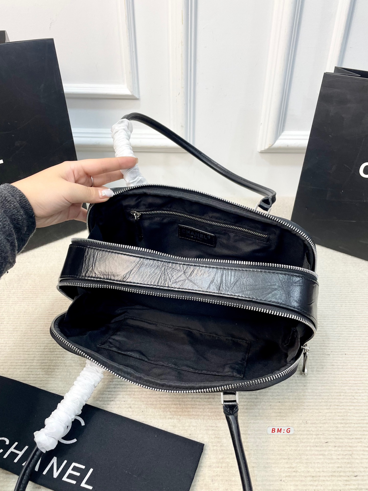 💰225 香奈儿黑色油蜡皮保龄球包，经典弧形设计，油蜡皮自带褶皱纹理，复古又高级✨。正面金属双C Logo超有辨识度，拉链开合更安全。内部空间合理，通勤休闲都能装。手柄弧形，手提肩背都OK，实用又时髦。 尺寸：31*9*16.5
