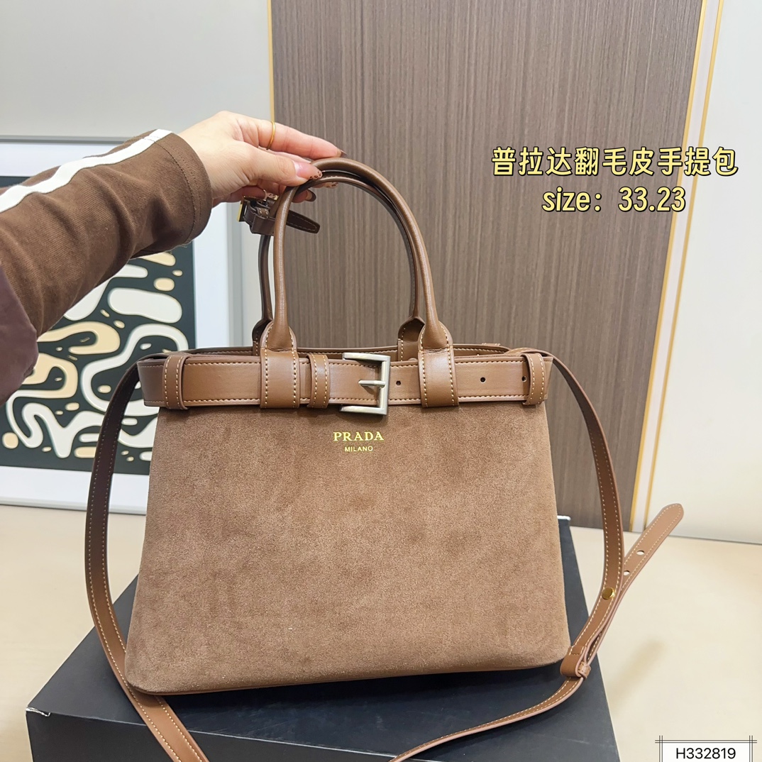 💰235 配盒⚠️尺寸33*23 Prada 普拉达 Buckle翻毛皮手提包 2024春夏系列，采用柔软麂皮，触感细腻，低调哑光质感超有氛围感。标志性金属腰带＋三角徽标，辨识度满分！尺寸适中中，通勤休闲都能轻松驾驱。肩带可拆卸调节，手提斜挎随心切换，实用又时髦。简约大气，时尚爱好者必入！