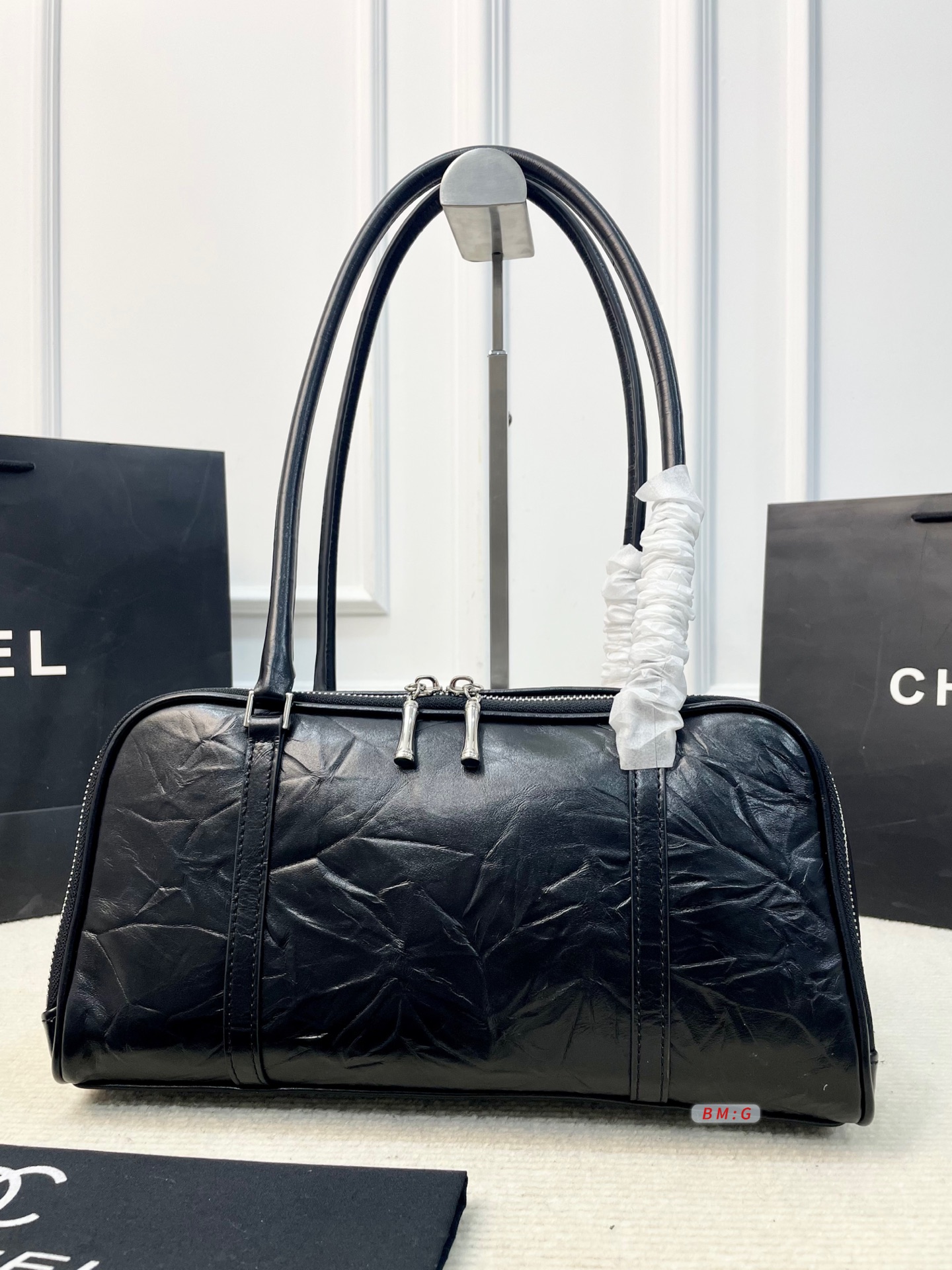💰225 香奈儿黑色油蜡皮保龄球包，经典弧形设计，油蜡皮自带褶皱纹理，复古又高级✨。正面金属双C Logo超有辨识度，拉链开合更安全。内部空间合理，通勤休闲都能装。手柄弧形，手提肩背都OK，实用又时髦。 尺寸：31*9*16.5