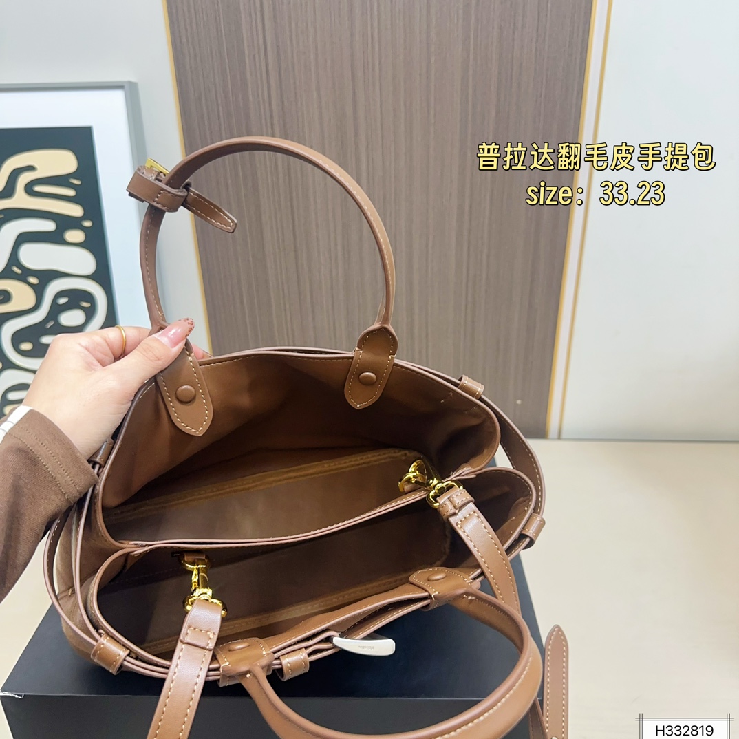 💰235 配盒⚠️尺寸33*23 Prada 普拉达 Buckle翻毛皮手提包 2024春夏系列，采用柔软麂皮，触感细腻，低调哑光质感超有氛围感。标志性金属腰带＋三角徽标，辨识度满分！尺寸适中中，通勤休闲都能轻松驾驱。肩带可拆卸调节，手提斜挎随心切换，实用又时髦。简约大气，时尚爱好者必入！