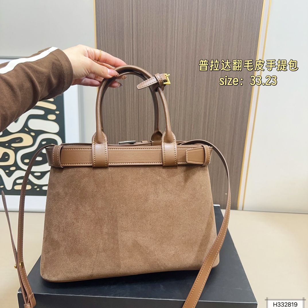 💰235 配盒⚠️尺寸33*23 Prada 普拉达 Buckle翻毛皮手提包 2024春夏系列，采用柔软麂皮，触感细腻，低调哑光质感超有氛围感。标志性金属腰带＋三角徽标，辨识度满分！尺寸适中中，通勤休闲都能轻松驾驱。肩带可拆卸调节，手提斜挎随心切换，实用又时髦。简约大气，时尚爱好者必入！