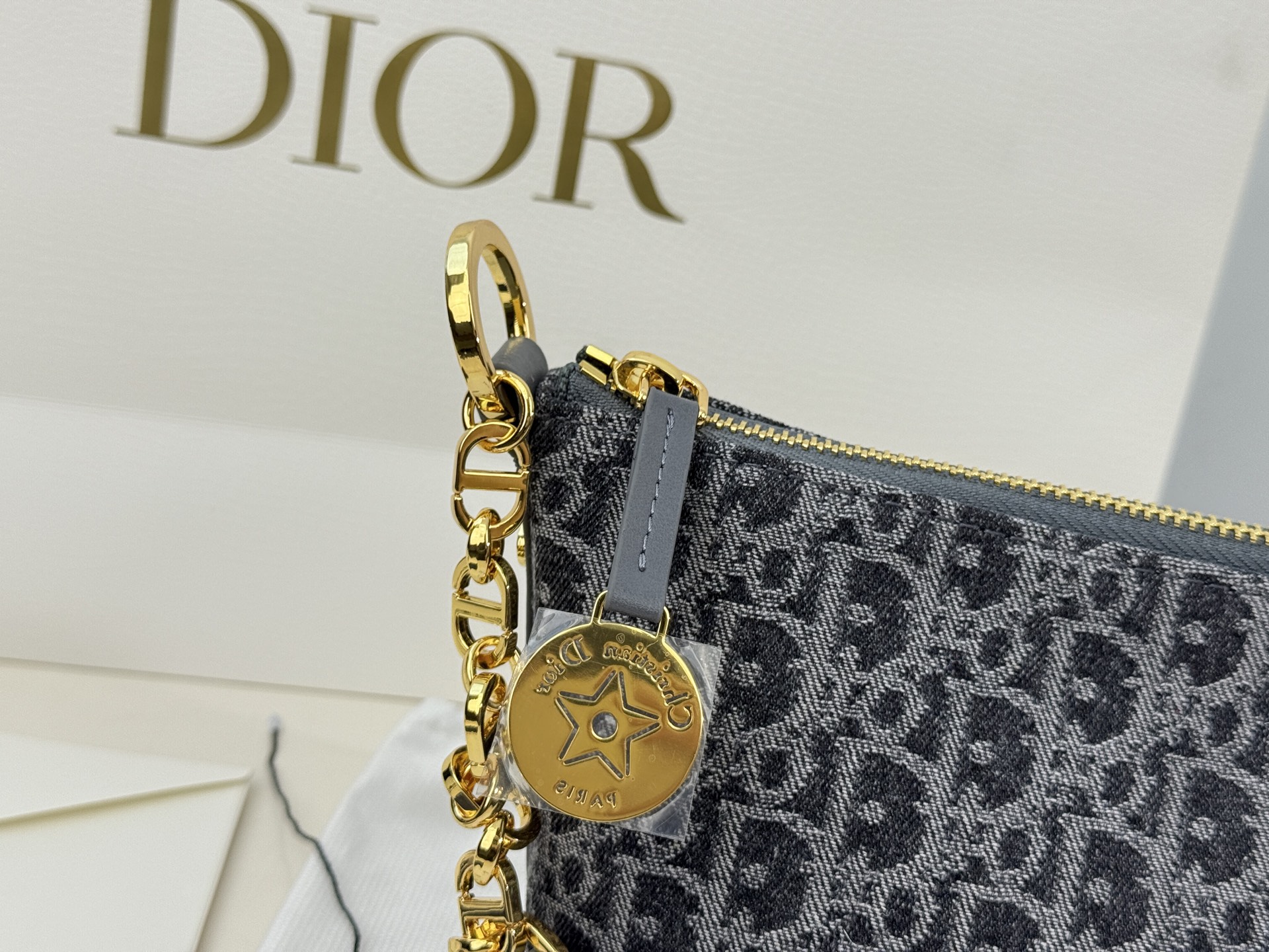 （折叠盒⚠️）p195 迪奥Dior 牛仔链条饭盒（自带延长带） 这款 Diorstar Hobo 链条手袋造型时尚，设计实用。采用蓝色 Denim Dior Oblique 提花面料精心制作，以不规则的石洗效果焕新演绎 Dior 的经典图案，彰显现代魅力，柔软版型搭配宽敞隔层。拉链开合，搭配镌刻以 Christian Dior Paris 标志和 Dior 经典星星标识的圆形饰牌，侧面饰以精致的 CD 铆钉，更显格调。内部带有绒面牛皮革里料，配有卡槽。搭配可调节的 CD 链条肩带，并带有皮革带，提升肩背时的舒适度。 size：22.16cm