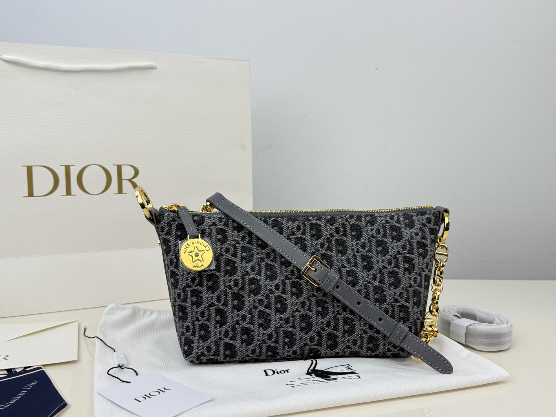 （折叠盒⚠️）p195 迪奥Dior 牛仔链条饭盒（自带延长带） 这款 Diorstar Hobo 链条手袋造型时尚，设计实用。采用蓝色 Denim Dior Oblique 提花面料精心制作，以不规则的石洗效果焕新演绎 Dior 的经典图案，彰显现代魅力，柔软版型搭配宽敞隔层。拉链开合，搭配镌刻以 Christian Dior Paris 标志和 Dior 经典星星标识的圆形饰牌，侧面饰以精致的 CD 铆钉，更显格调。内部带有绒面牛皮革里料，配有卡槽。搭配可调节的 CD 链条肩带，并带有皮革带，提升肩背时的舒适度。 size：22.16cm