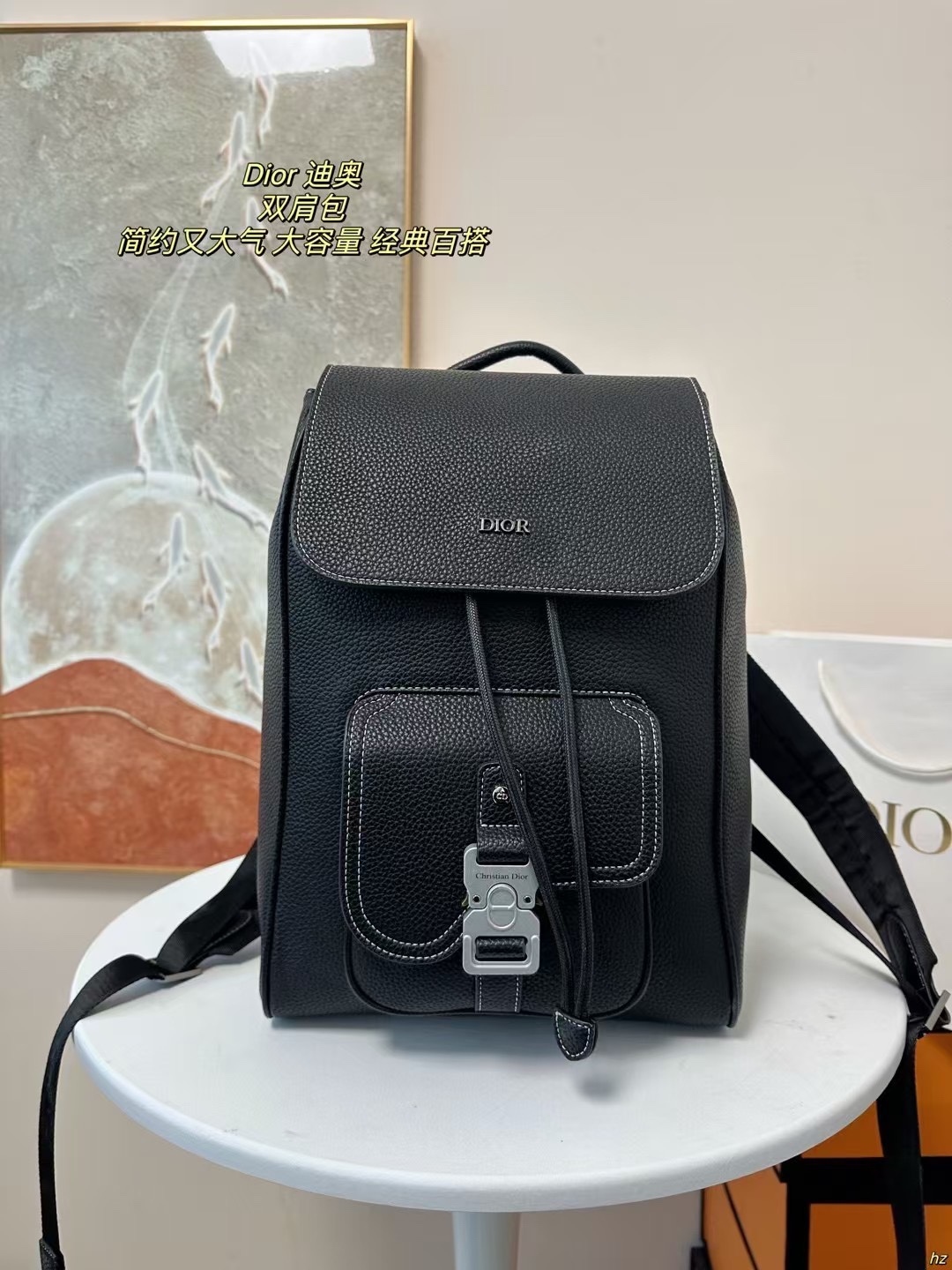 P185 Dior 迪奥 双肩包 这款马鞍双肩背包是二零二四秋季男装系列新品，采用时尚的原创设计，突显马鞍风格。黑色粒面牛皮革搭配对比鲜明的缉面线，正面饰以Dior标志。空间宽敞，设有一个隔层,可收纳各种日常用品，正面马鞍翻盖，可收纳钱包、钥匙、耳机或手机,便于轻松取用。实用百搭，是各式造型的点睛之笔。 尺寸：28*42CM