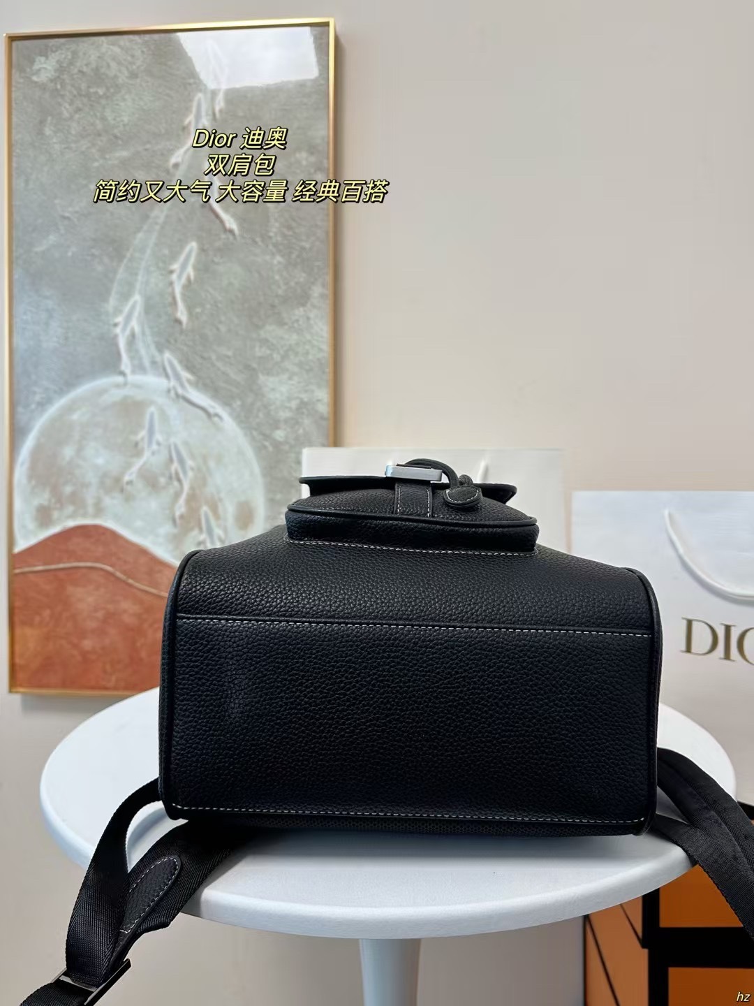 P185 Dior 迪奥 双肩包 这款马鞍双肩背包是二零二四秋季男装系列新品，采用时尚的原创设计，突显马鞍风格。黑色粒面牛皮革搭配对比鲜明的缉面线，正面饰以Dior标志。空间宽敞，设有一个隔层,可收纳各种日常用品，正面马鞍翻盖，可收纳钱包、钥匙、耳机或手机,便于轻松取用。实用百搭，是各式造型的点睛之笔。 尺寸：28*42CM