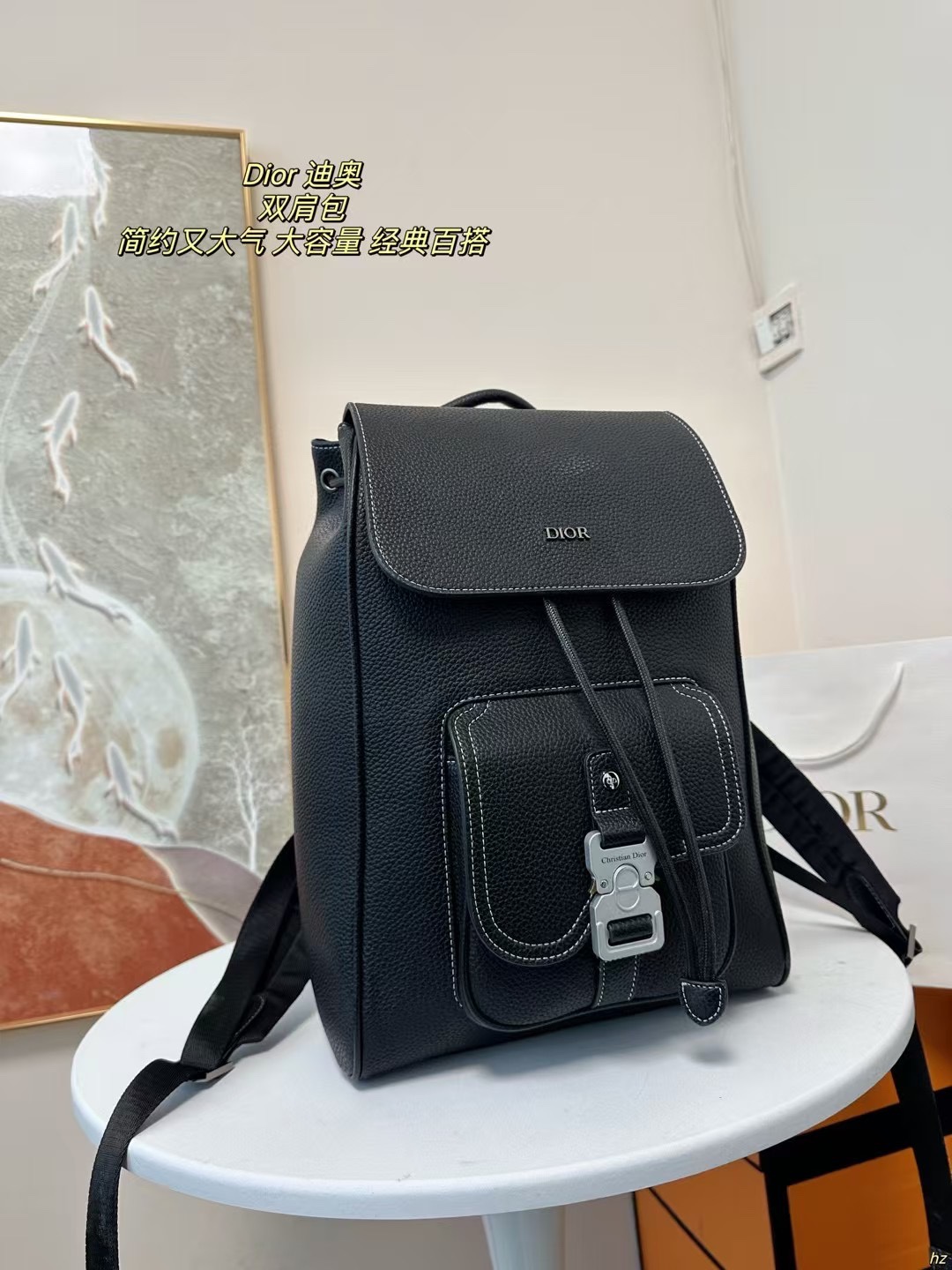 P185 Dior 迪奥 双肩包 这款马鞍双肩背包是二零二四秋季男装系列新品，采用时尚的原创设计，突显马鞍风格。黑色粒面牛皮革搭配对比鲜明的缉面线，正面饰以Dior标志。空间宽敞，设有一个隔层,可收纳各种日常用品，正面马鞍翻盖，可收纳钱包、钥匙、耳机或手机,便于轻松取用。实用百搭，是各式造型的点睛之笔。 尺寸：28*42CM