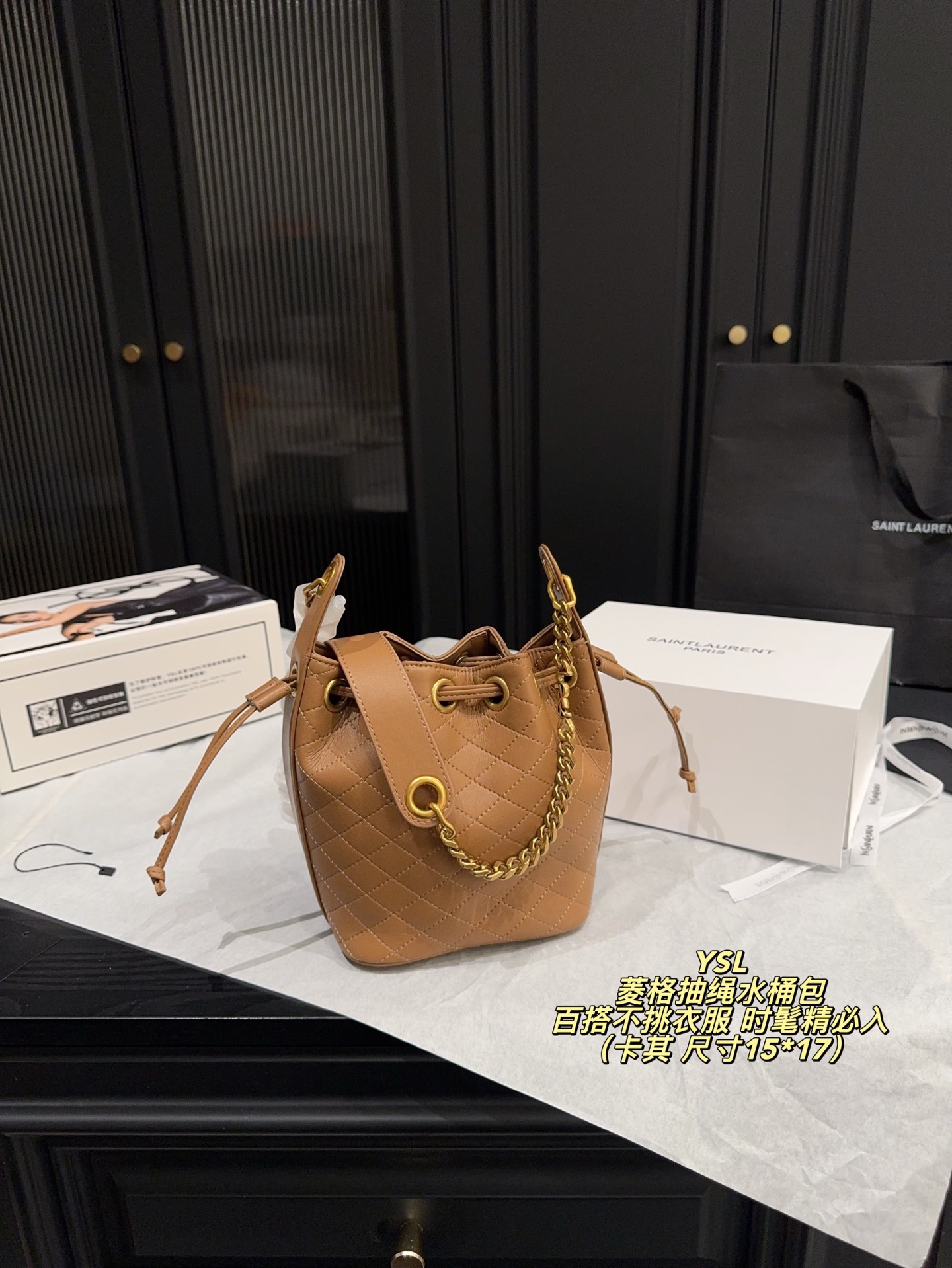 P180全套包装⚠️尺寸15*17 圣罗兰 YSL 菱格抽绳水桶包 经典黑色小牛皮＋金色链条，优雅又高级。抽绳开合，容量大，通勤出街都超实用！菱格纹缝线细节满分，链条肩带可调节，单肩斜挎都OK，百搭不挑衣服~轻奢时尚感拉满，是圣罗兰热门款，时髦精必入！