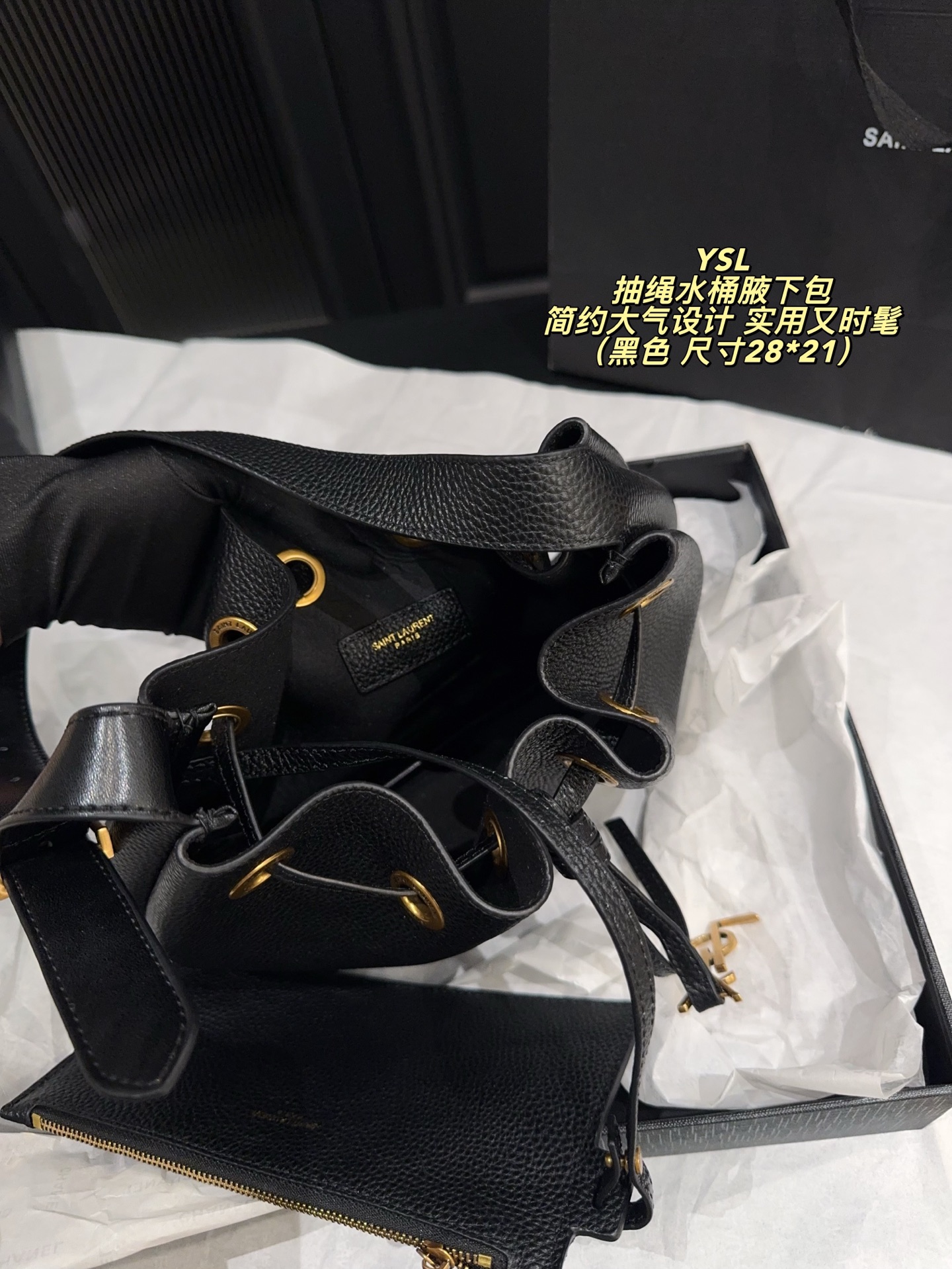 P200配折叠盒⚠️尺寸28*21 圣罗兰 YSL 抽绳水桶腋下包 黑色荔枝纹牛皮，质感细腻耐用，金属抽绳十YSL标志超有辨识度。尺寸适中，通勤休闲都能用，手提斜挎随心切换，内部空问合理，日常物品轻松收纳。简约大气设计，百搭不挑风格，秋冬深色系穿搭必备，实用又时髦！