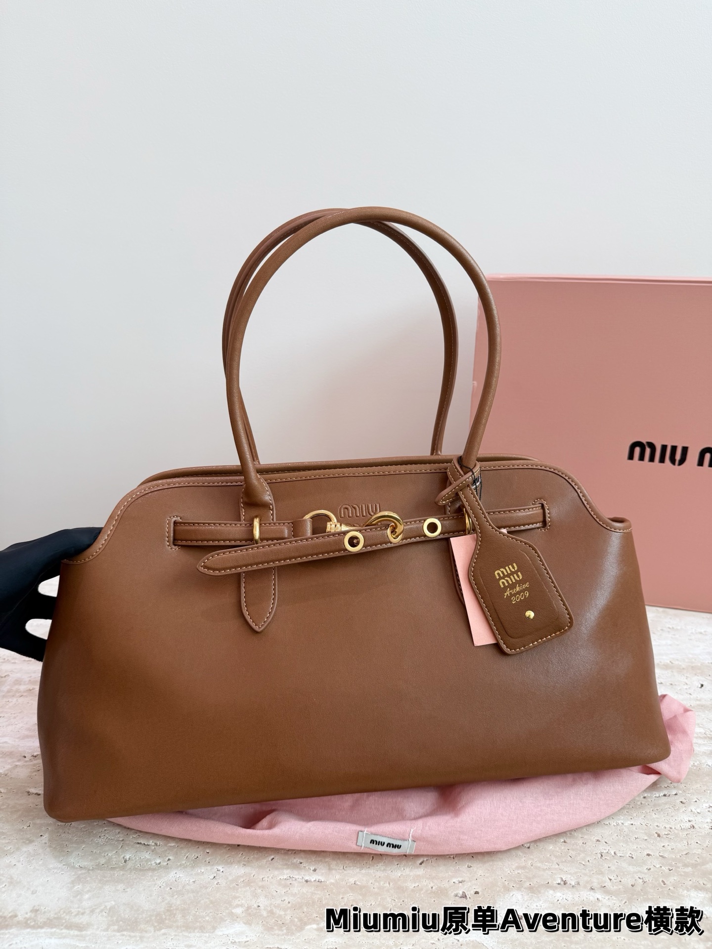 P240 miumiu复古Aventure系列贝壳包 Aventure系列贝壳手提/斜挎包.上线啦! 24ss最流行款式，做旧褪色感的皮革颜色与质地，配上金属皮带搭扣高级又复古，采用小牛皮制作的包身设计精致，方正复古的造型 手提腋下斜挎包随意切换! 优雅通勤超好穿快快加入miu女孩吧! 尺寸:超大号46*23cm复古包#牛皮包包